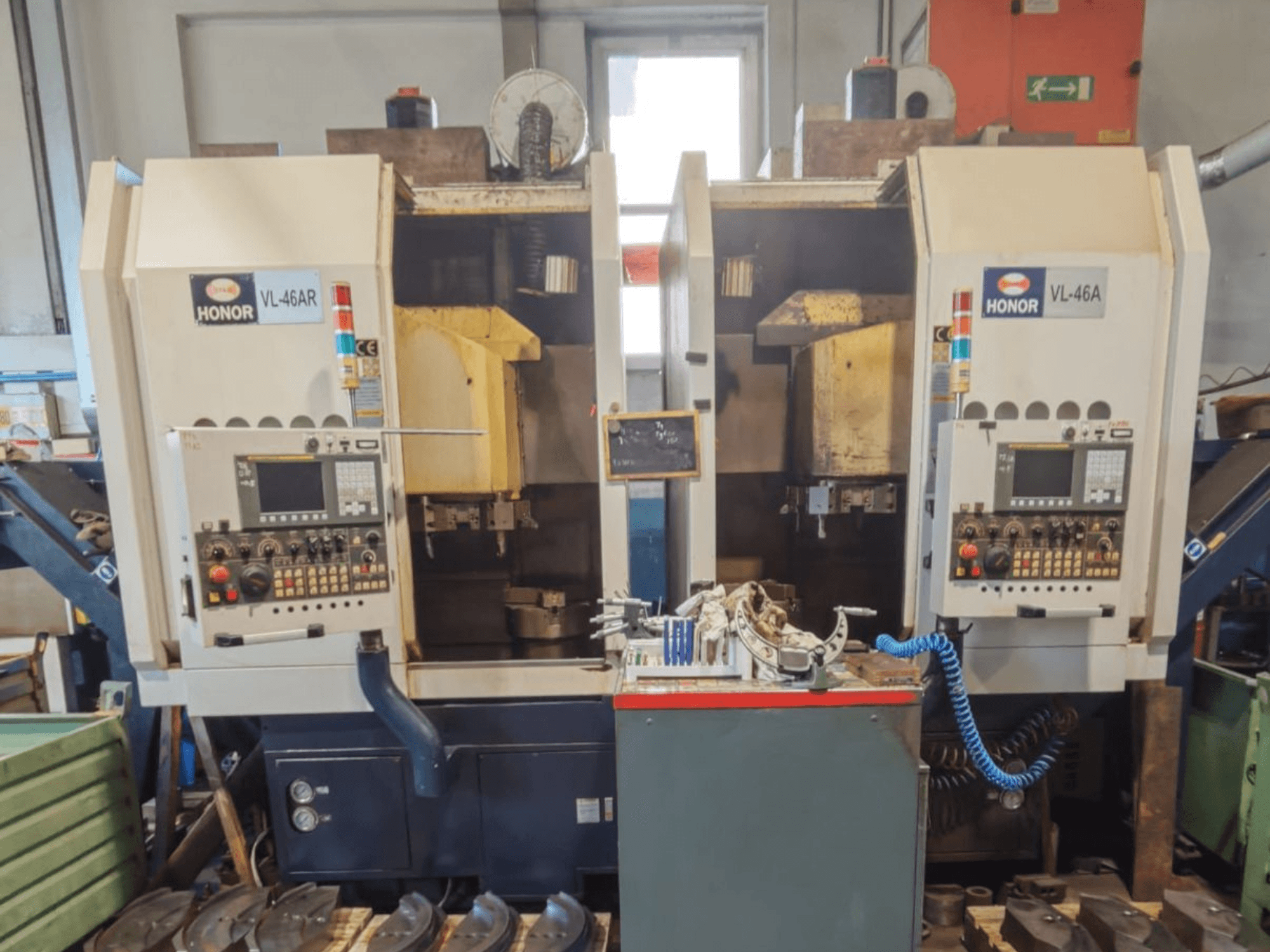 Verticale draaibank HONOR SEIKI VL 46 AR met twee werkstations, vooraanzicht met bedieningspanelen en gereedschappen.
