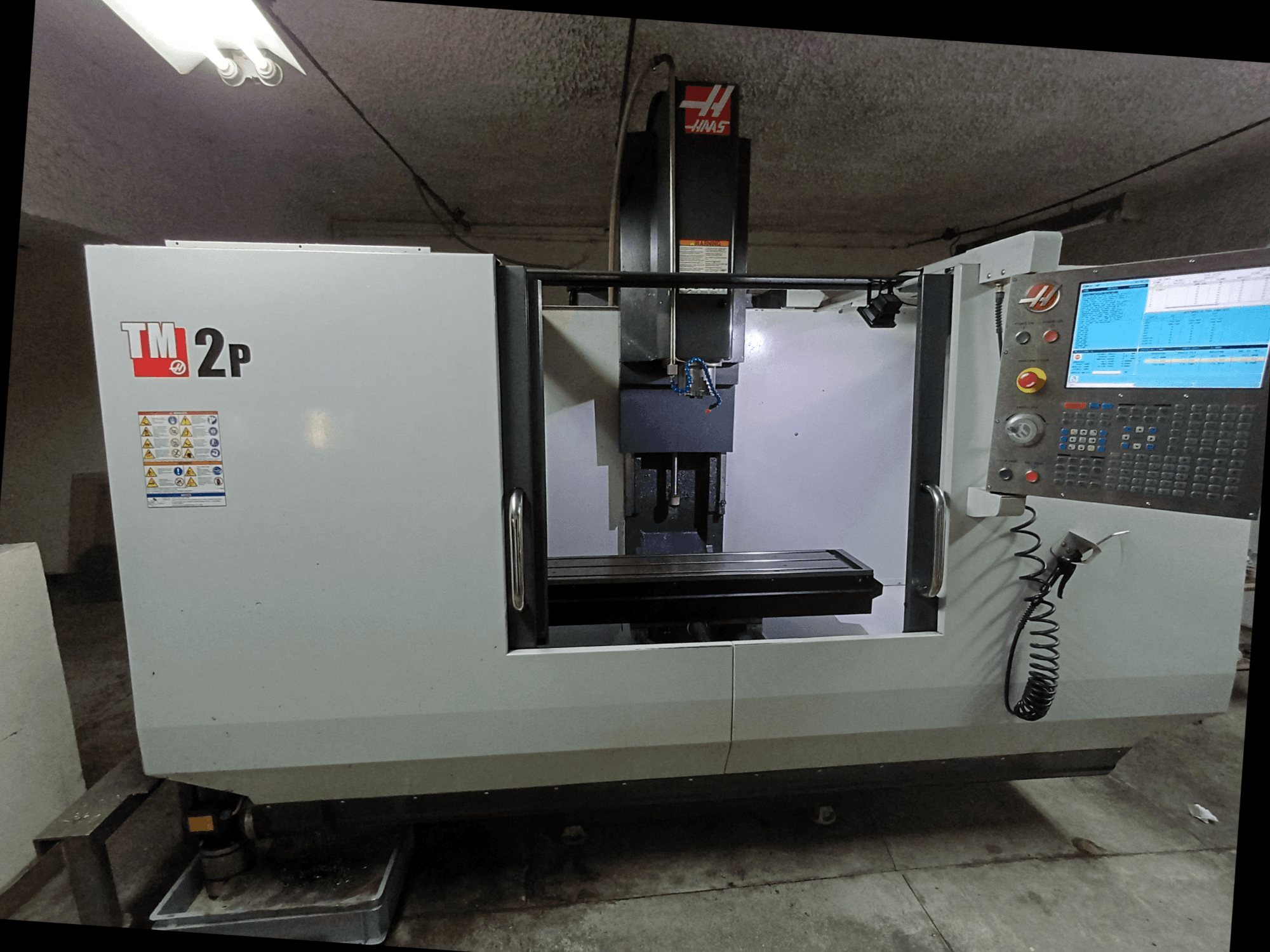 HAAS TM-2P verticaal bewerkingscentrum, vooraanzicht, met bedieningspaneel, spindelkop en machinebed.