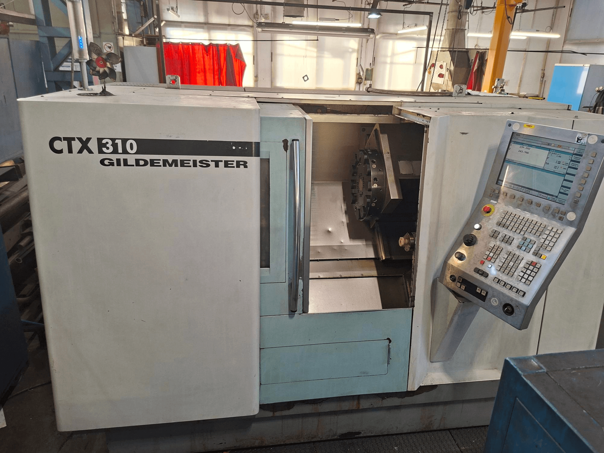 Horizontale draaimachine DMG CTX 310, vooraanzicht, met bedieningspaneel en open toegang tot het werkgebied.