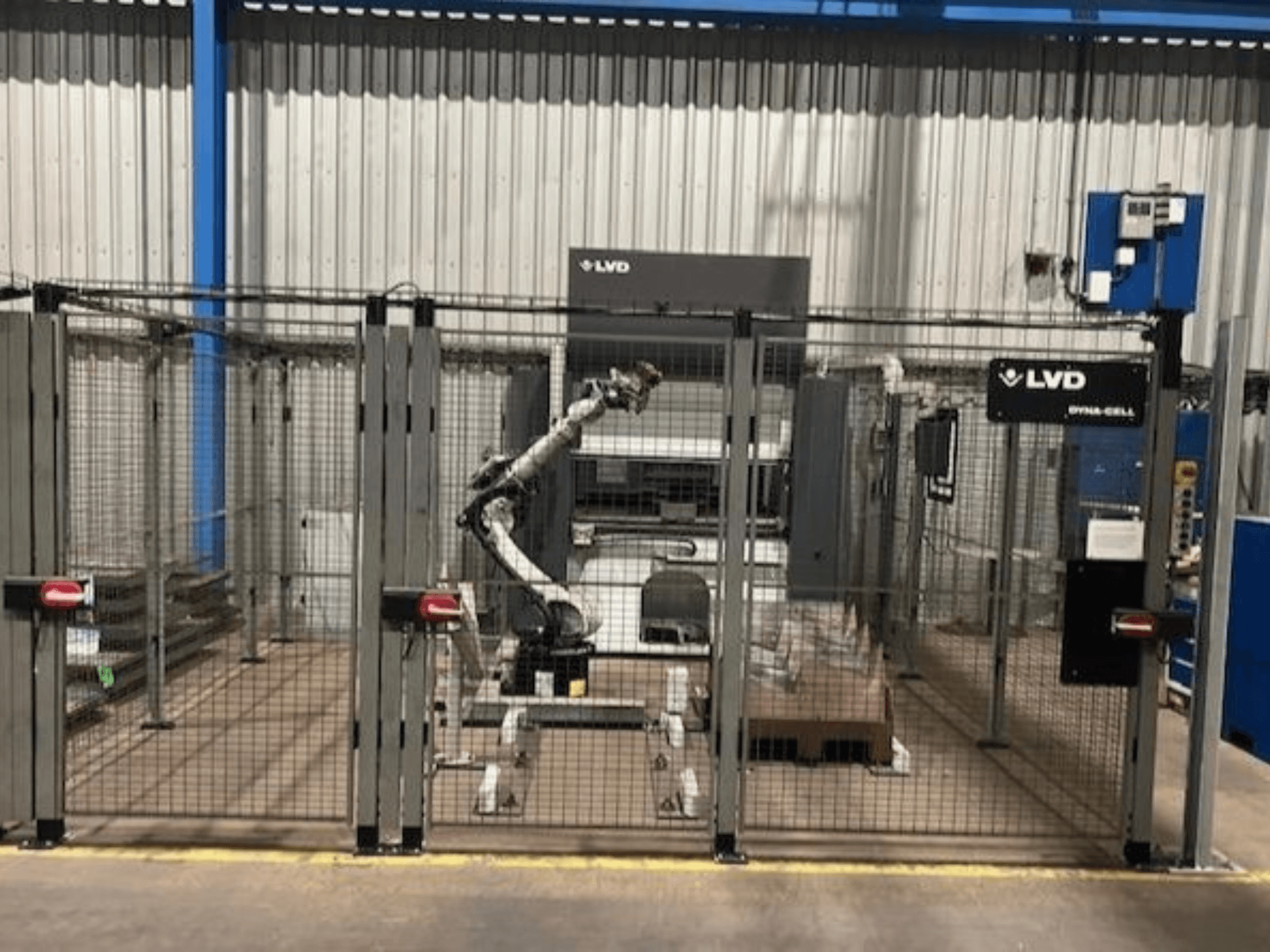 LVD Dyna-Cell robotwerkstation in een omheinde behuizing, vooraanzicht, met robotarm en bedieningspaneel.