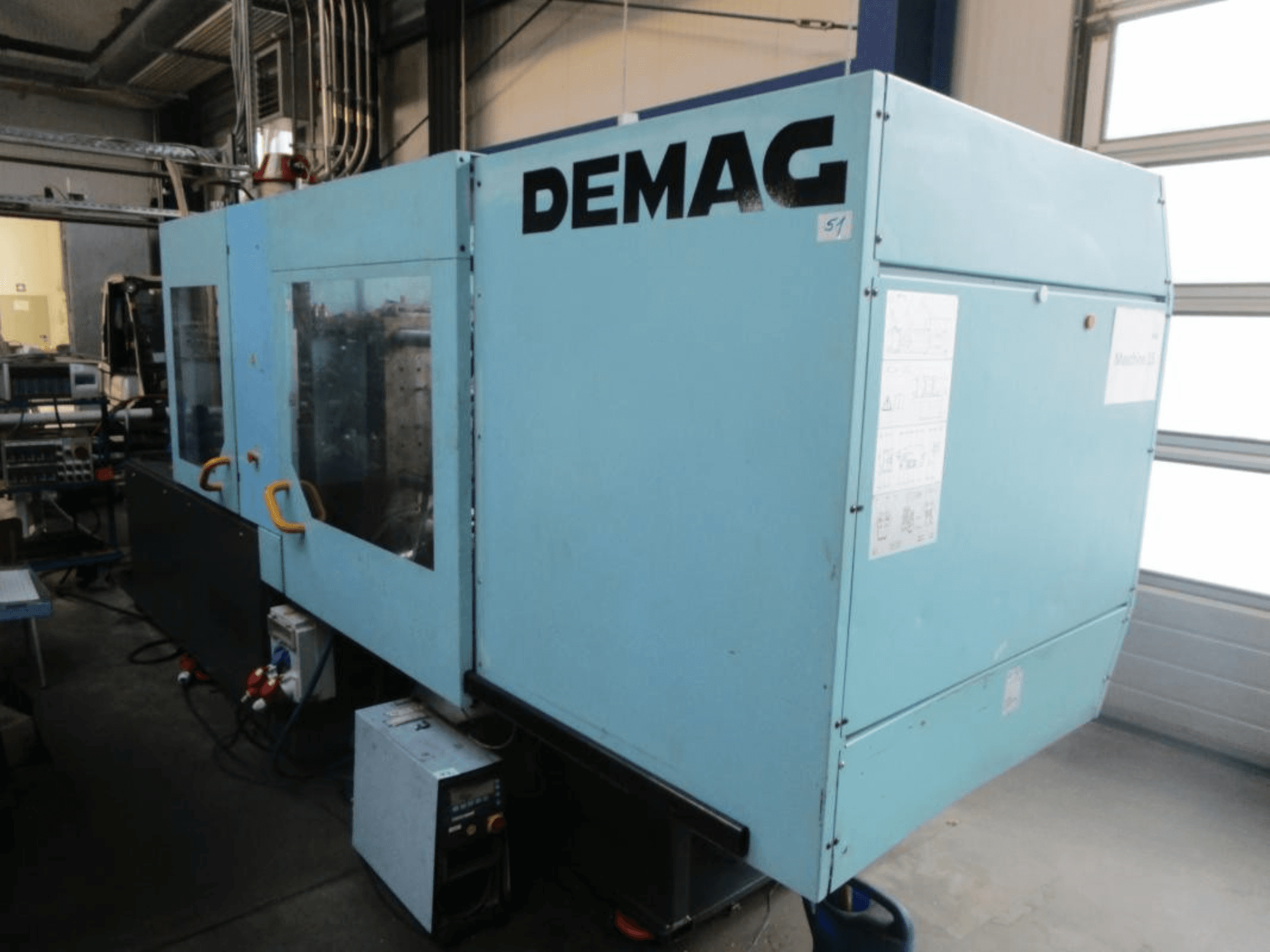 Vooraanzicht van een DEMAG Ergotech 150-610 Viva hydraulische spuitgietmachine, met zichtbaar bedieningspaneel en handgrepen.