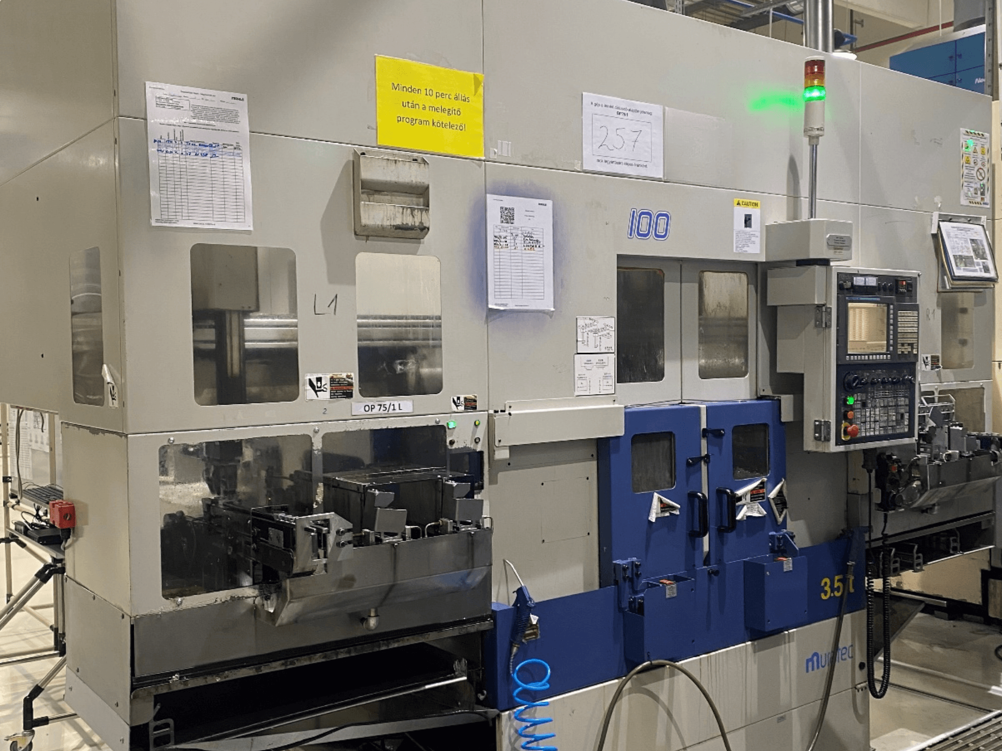 MURATA MW100 horizontale draaimachine in een fabrieksomgeving, vooraanzicht met weergave van het bedieningspaneel en operationele details.