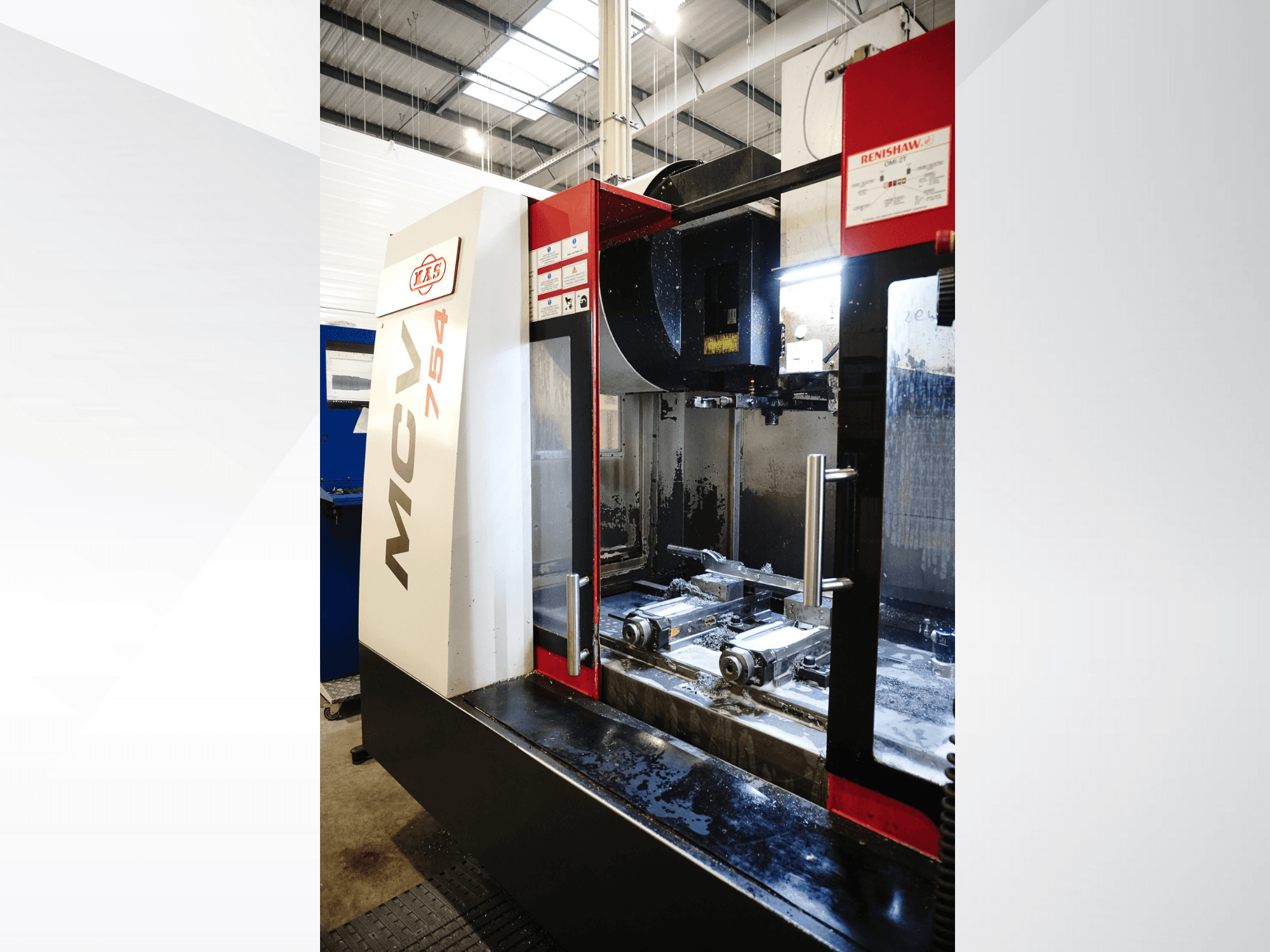 TAKUMI MCV 754 CNC freesmachine, vooraanzicht, met metaalschilfers en precisiegereedschap in een werkplaats.