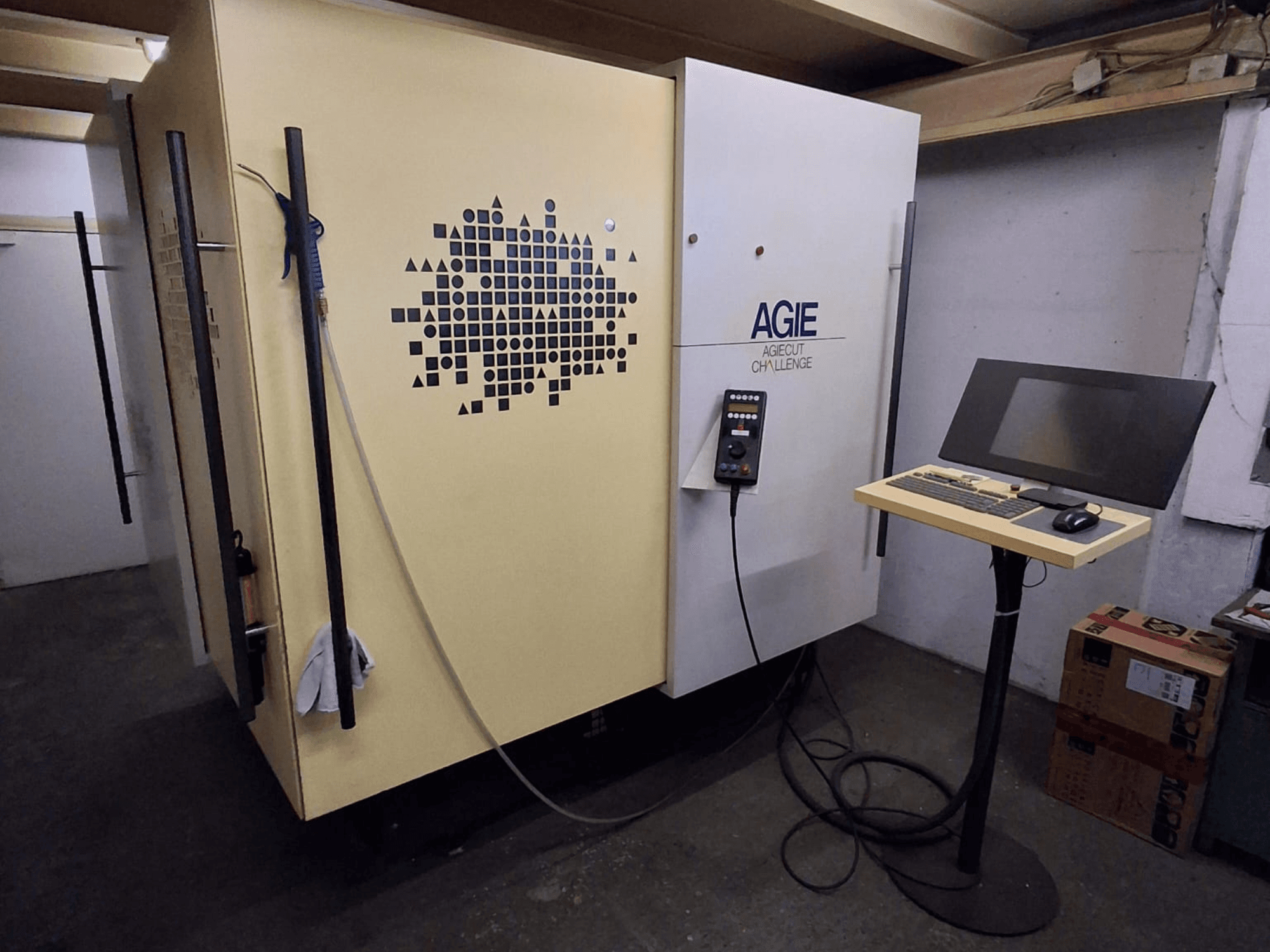 AGIE Agiecut Challenge 2-draads vonkmachine in een werkplaats, met bedieningspaneel en monitor op een standaard, vooraanzicht.
