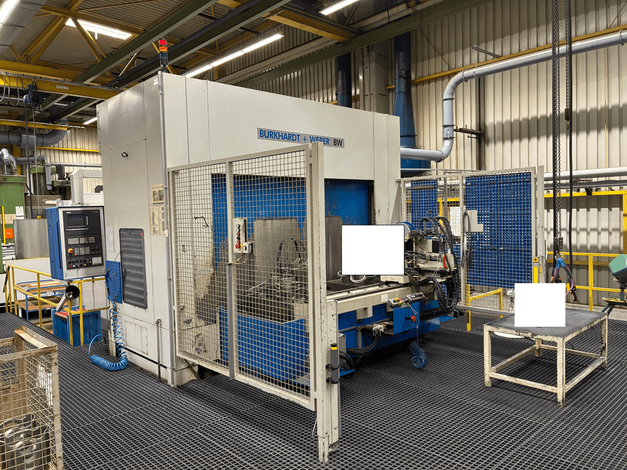 Burkhardt + Weber BW bewerkingscentrum, vooraanzicht, met bedieningspaneel en veiligheidsbehuizing, geplaatst in een industriële omgeving.