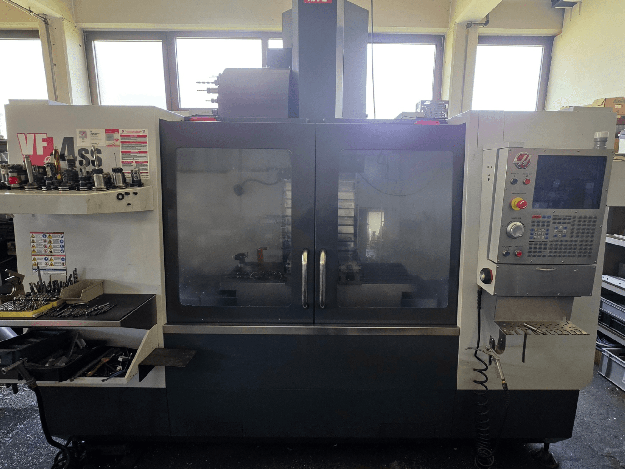 HAAS VF 34SS verticaal bewerkingscentrum vooraanzicht, met het bedieningspaneel en de gereedschapopslag.