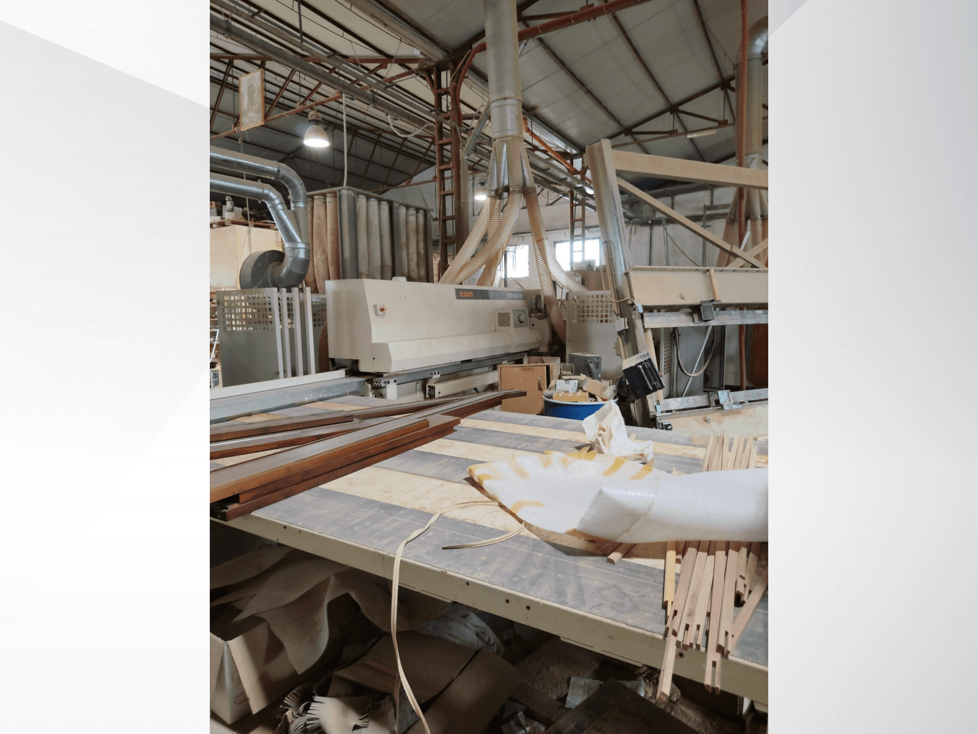 CNC-houtbewerkingscentrum SCM Windor60 in een werkplaats, gezien vanaf de zijkant met houten panelen en stofafzuiging.
