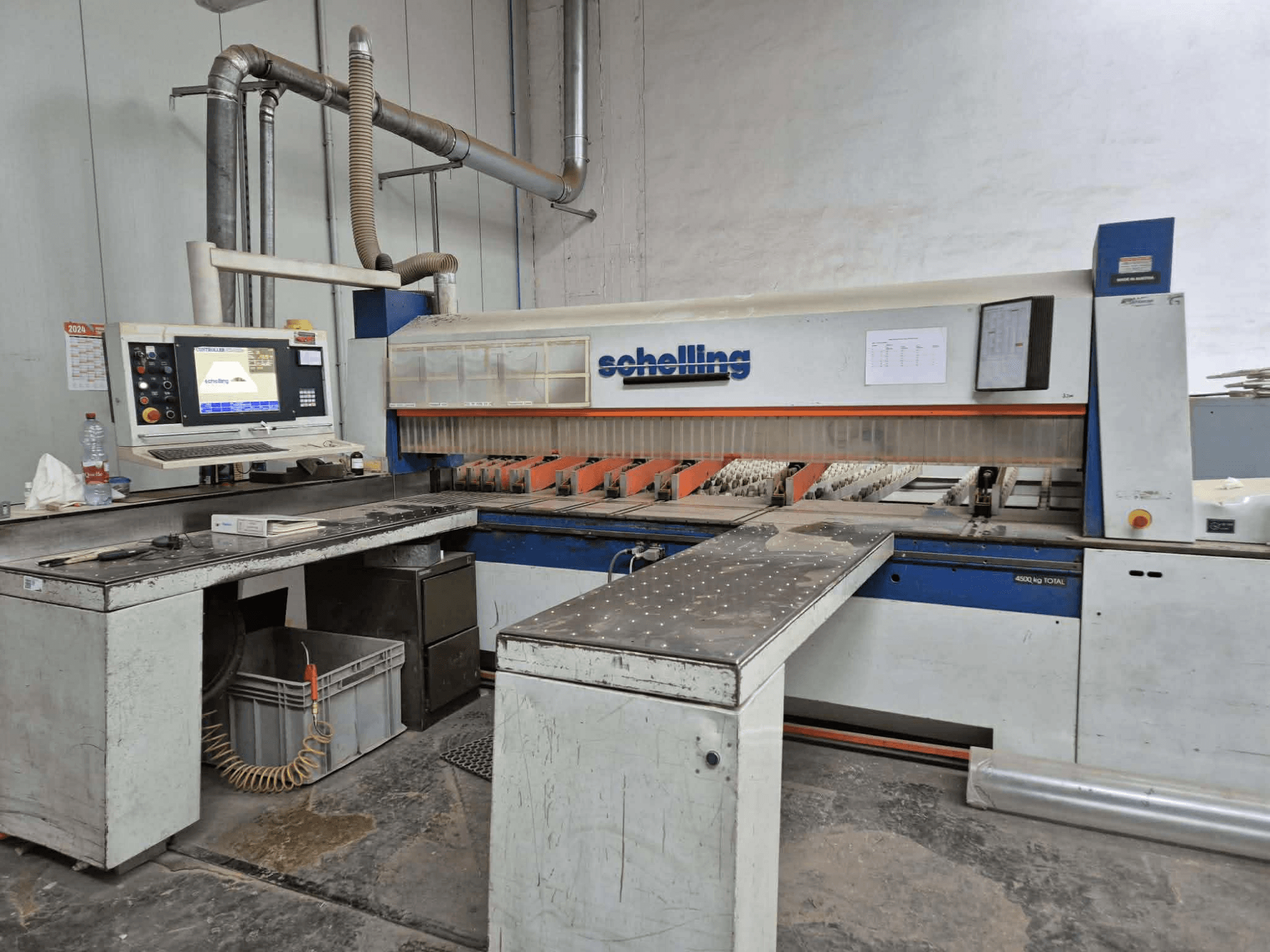 Schaublin snijmachine in zijaanzicht, met een computerinterface, scherpe messen en een stevig metalen werkblad.