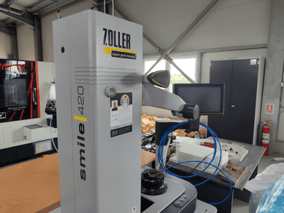 ZOLLER smile 420 meetapparaat met monitor, zijaanzicht in een werkplaats, met blauwe slangen en machines op de achtergrond.