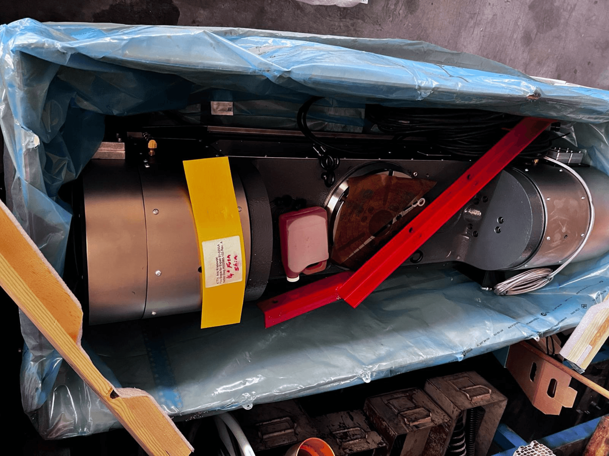 Het motorapparaat is gedeeltelijk zichtbaar in de verpakking, heeft een zilveren buitenkant, kleurrijke meters en een rode steunbeugel.