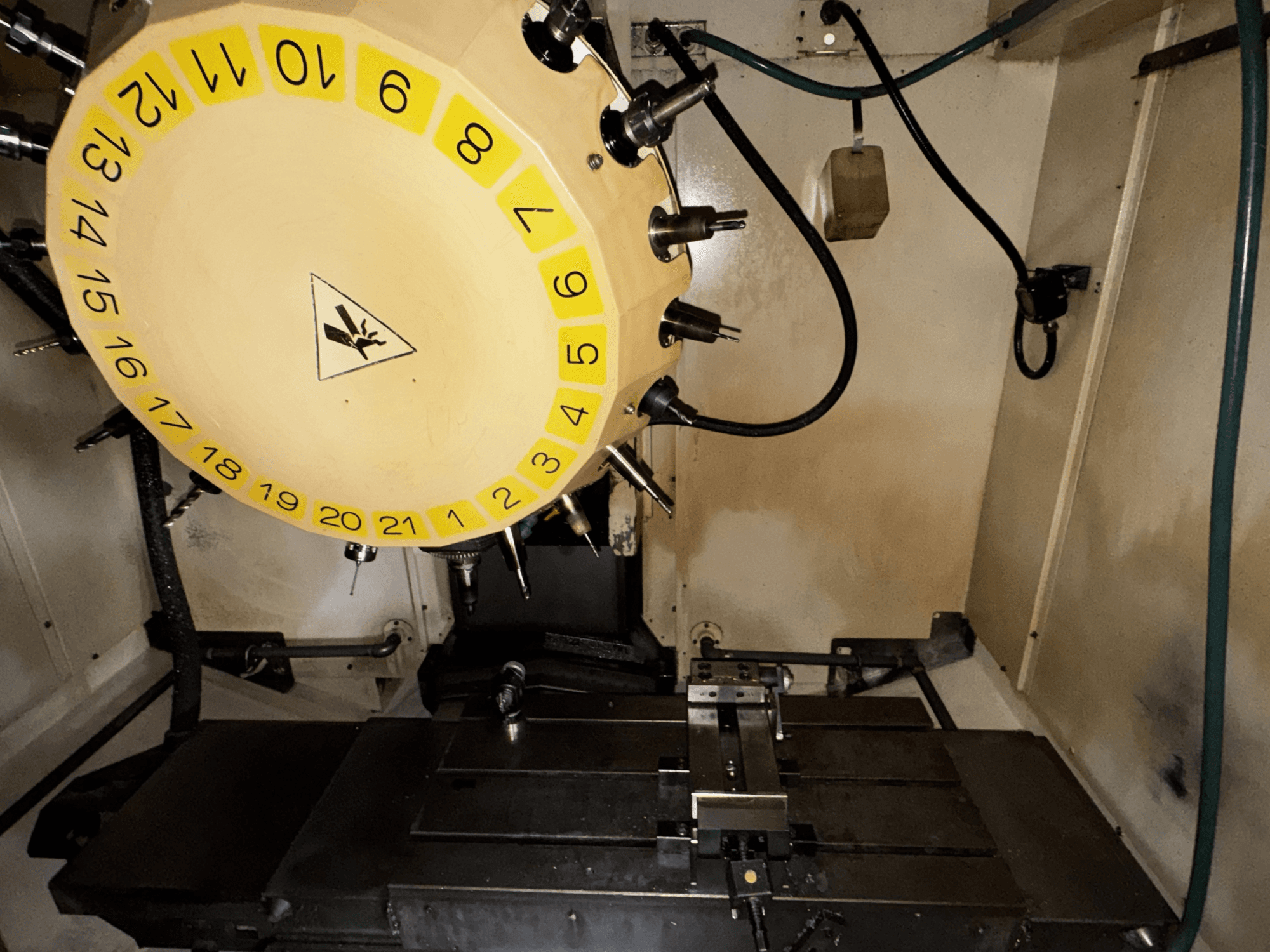 FANUC Robodrill alpha-T21iFL verticaal bewerkingscentrum binnenaanzicht met gereedschapscarrousel en bewerkingstafel zichtbaar.