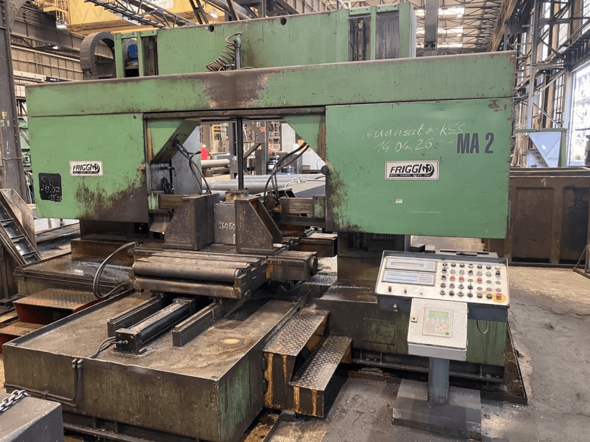 Friggi 2MF/AUT metalen lintzaag, vooraanzicht met bedieningspaneel, zaagbladgedeelte en tafelopstelling in een werkplaatsomgeving.
