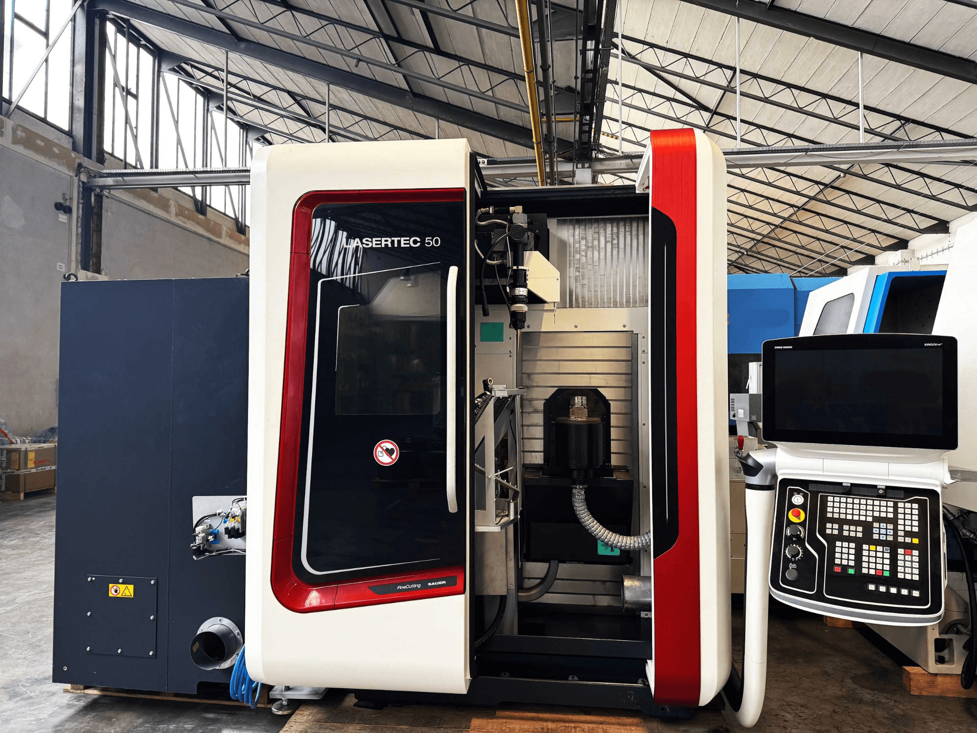 LaserTec 50 CNC machine in zijaanzicht, met zwart-wit bedieningspaneel, zichtbare gereedschaphouder en industriële instelling.