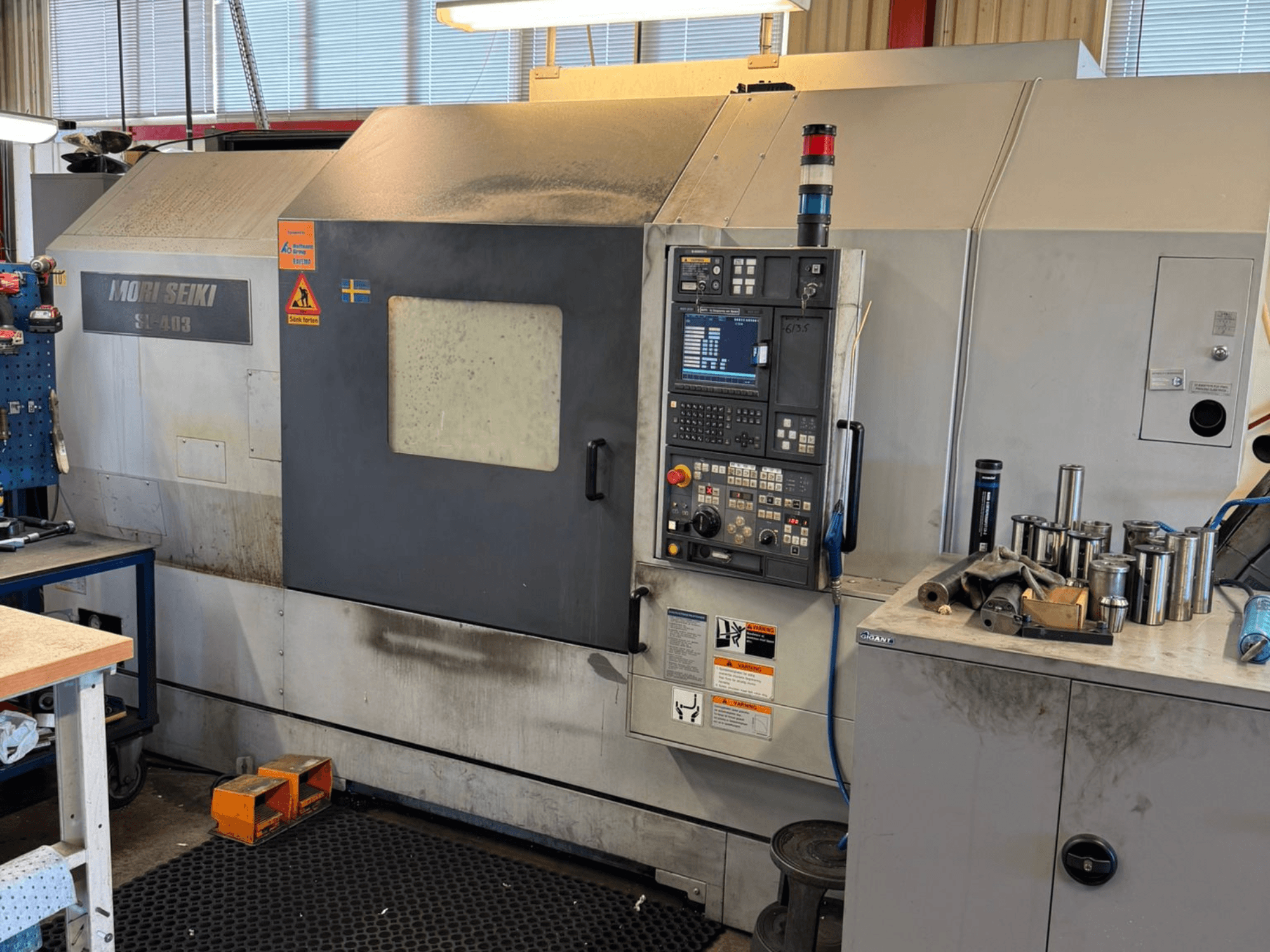 MORI SEIKI SL-403BMC/800 horizontale draaimachine in een werkplaats, met het bedieningspaneel en nabijgelegen gereedschappen, zijaanzicht.