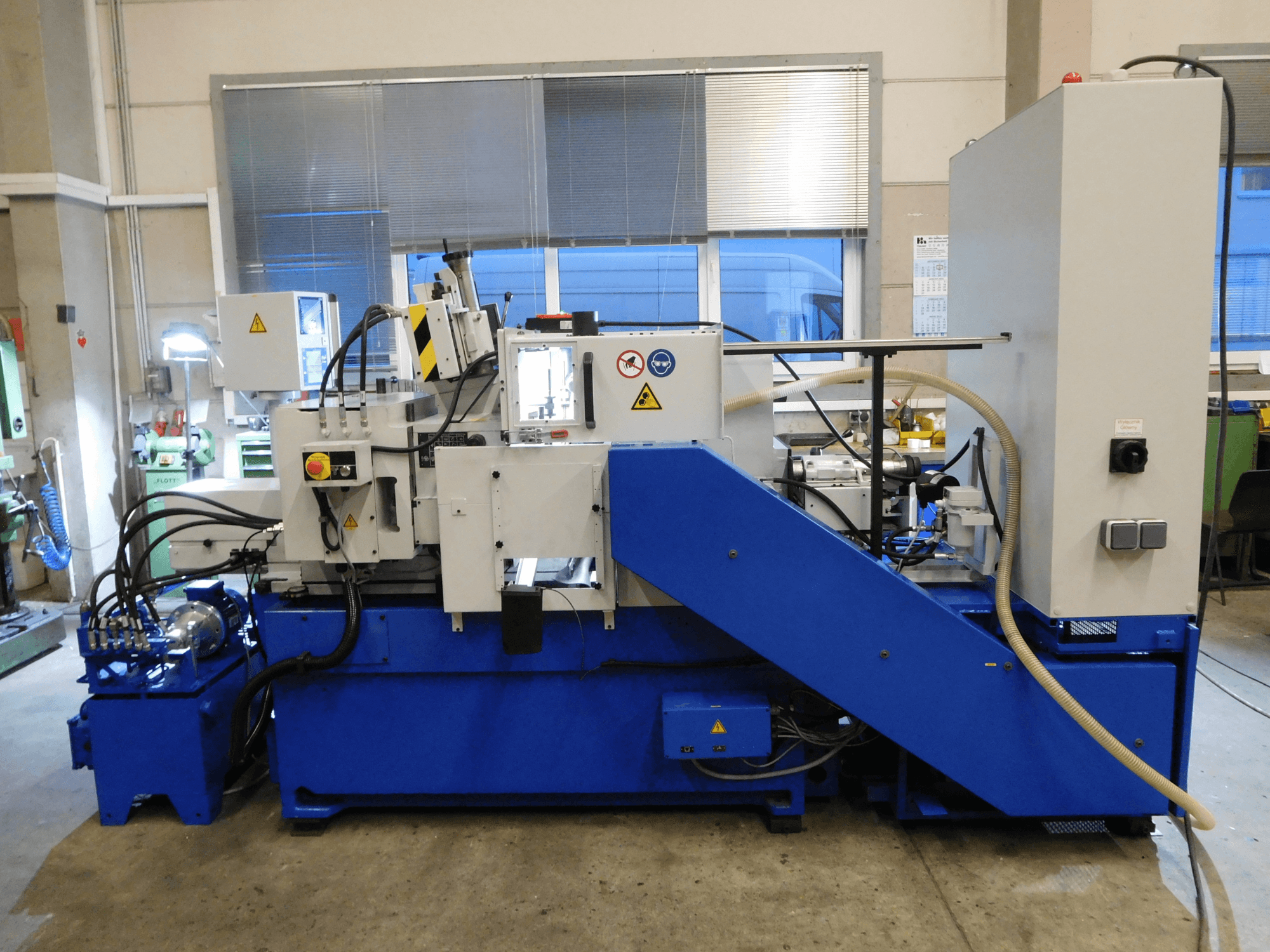Schaudt Mikrosa SASL 125 centerloze slijpmachine, zijaanzicht, met blauwe voet en bedieningspaneel, die de operationele functies toont.
