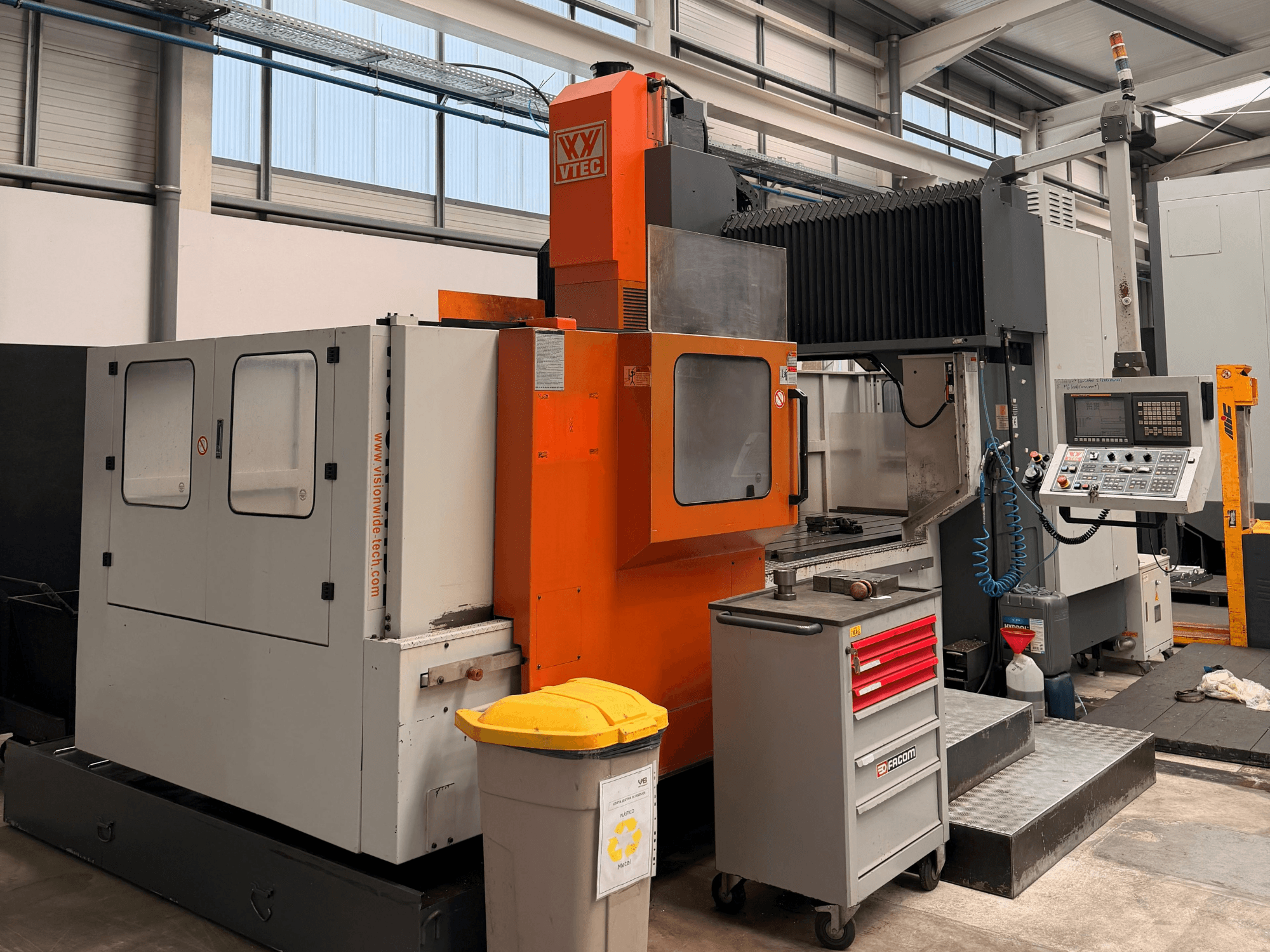 Vision Wide Vision-portaalfreesmachine, vooraanzicht, met daarin de bedieningselementen, de schakelkast en de gereedschapopslag in een werkplaatsomgeving.