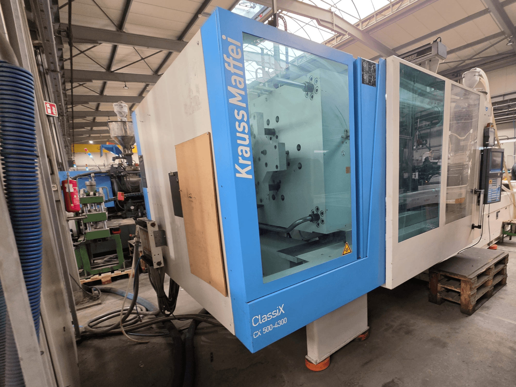 Krauss Maffei 500-4300 CX hydraulische spuitgietmachine, zijaanzicht, met het bedieningspaneel en de operationele onderdelen.