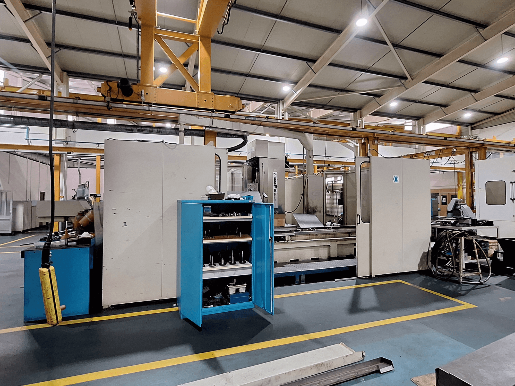 Portaalfreesmachine Rambaudi RX 1250, vooraanzicht met gereedschapopslag, in een ruime industriële werkruimte.