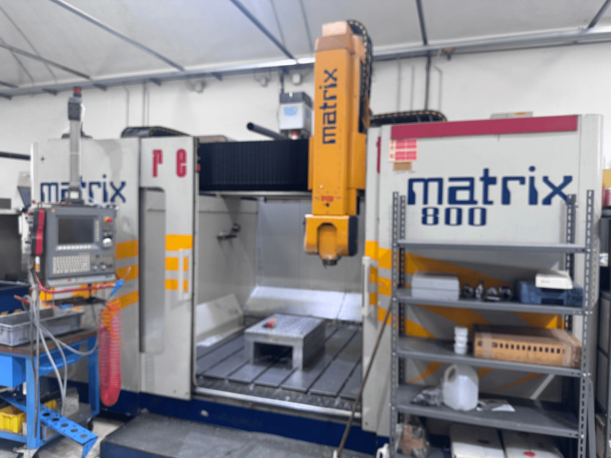 Matrix 800 CNC machine in een werkplaatsaanzicht, met bedieningspaneel, gereedschappen en werktafel met verschillende objecten.
