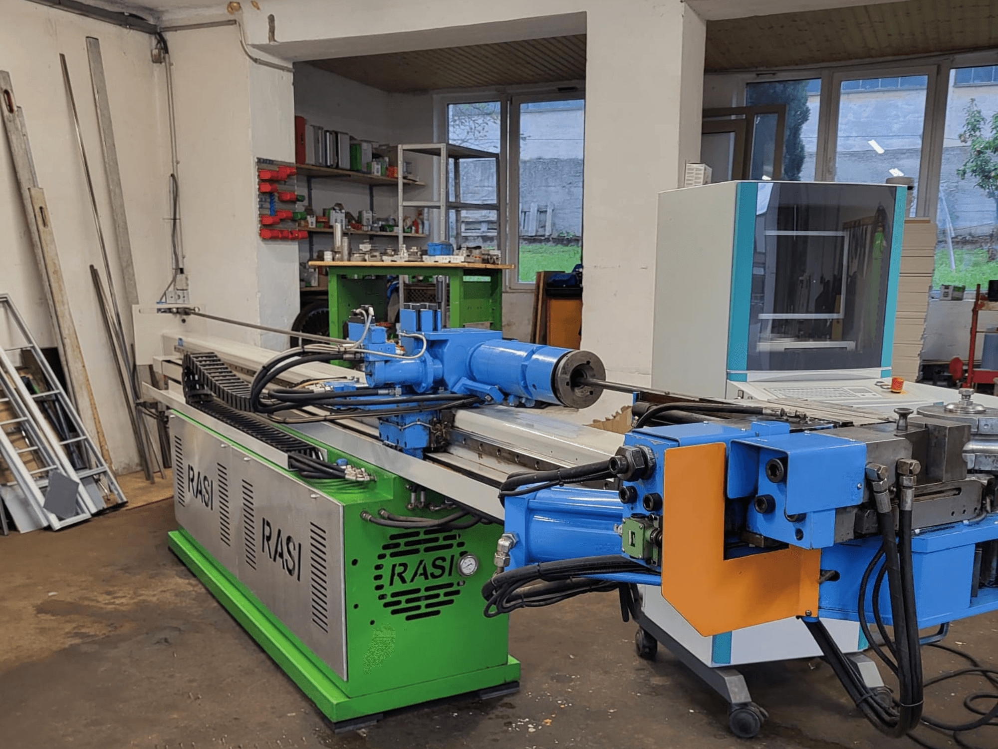 Rasi S 80.6 L G-V3C50 werktuigmachine in werkplaatsopstelling, zijaanzicht met blauwe en groene componenten en bedieningspaneel.