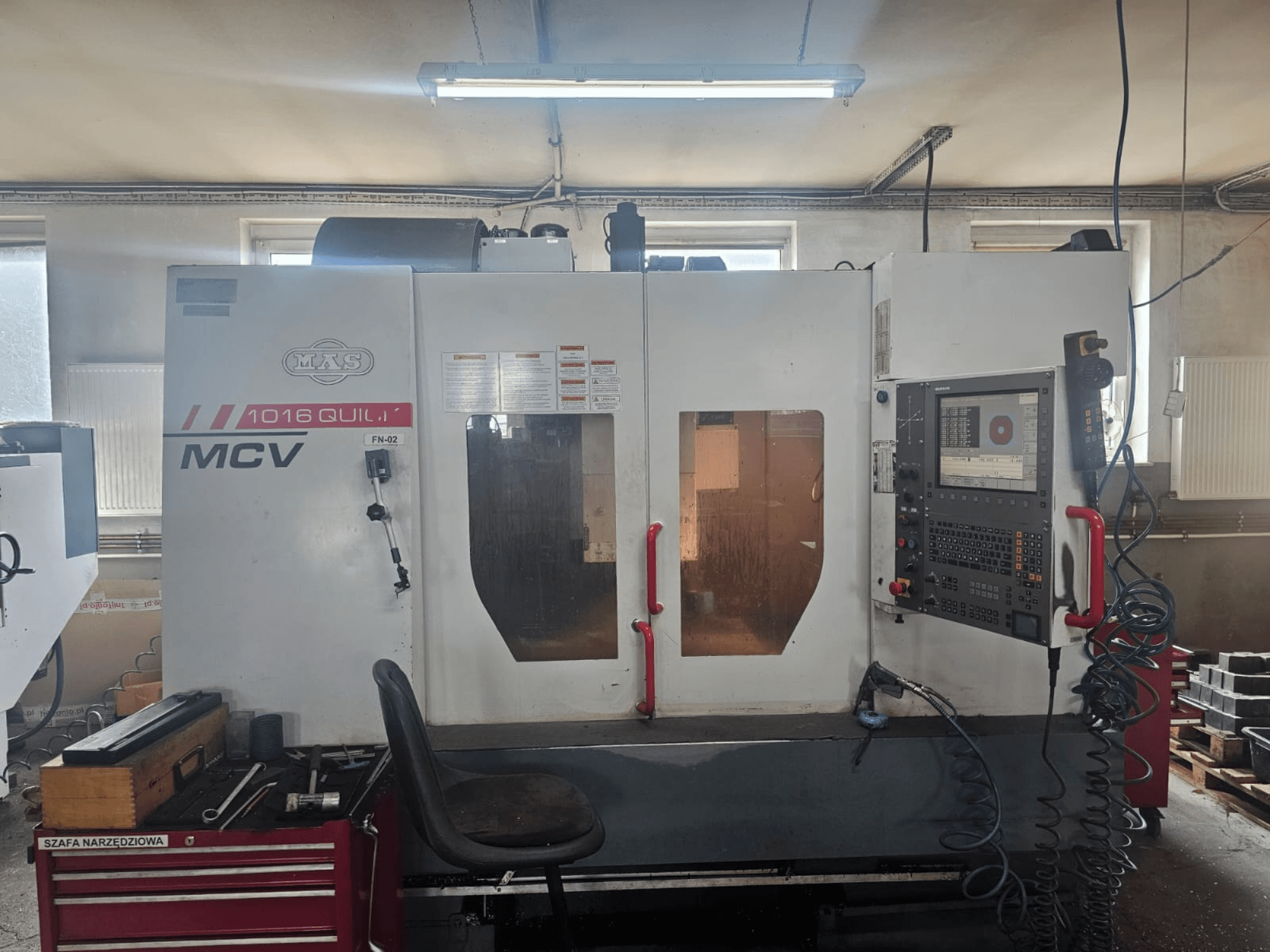 MVS MCV 1016 QUILL CNC machine, vooraanzicht, met bedieningspaneel, gereedschapslade en werkruimte met gereedschappen.