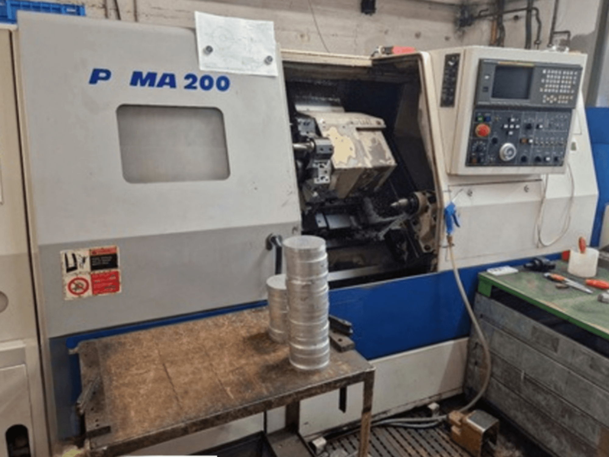 DAEWOO EcoTurn 200 horizontale draaimachine, vooraanzicht, met aluminium werkstukken op een tafel, bedieningspaneel zichtbaar.