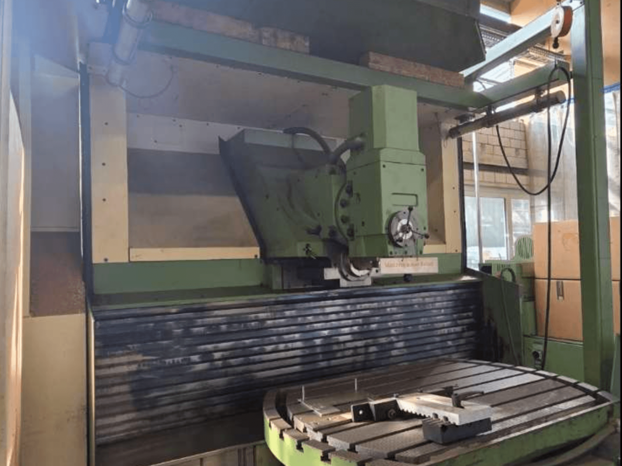 MAHO MH1000 C Universeel Bewerkingscentrum in vooraanzicht, met de groene structuur, de spindel en de draaitafel met een werkstuk.