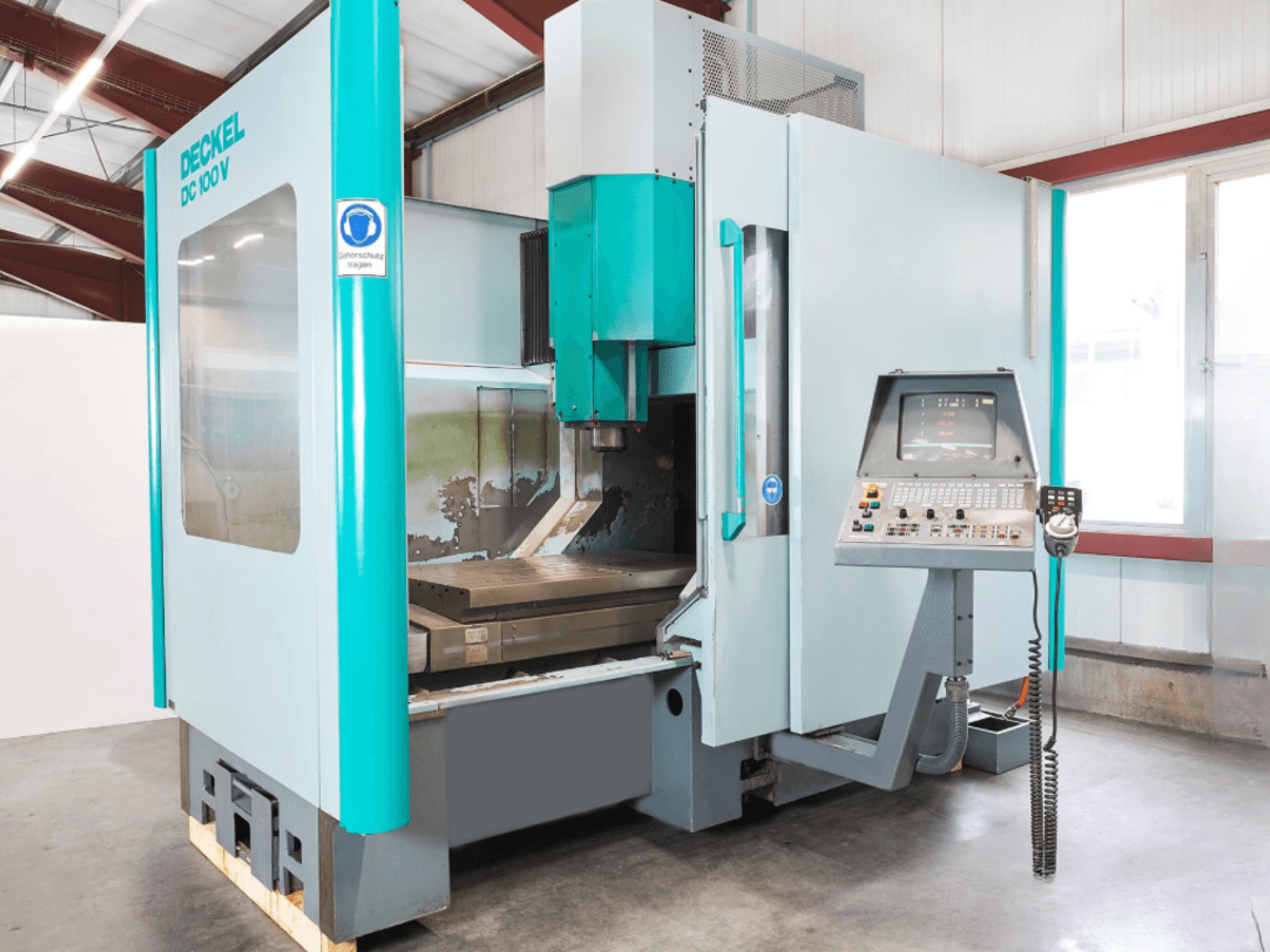 Deckel DC 100 V verticaal bewerkingscentrum, vooraanzicht, met digitaal bedieningspaneel en snijtafel.