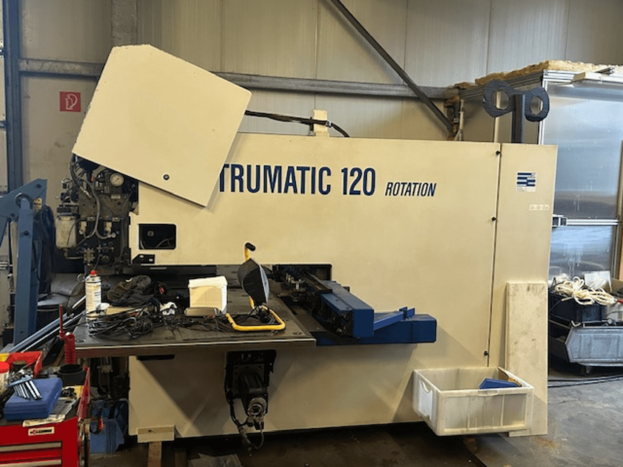 TRUMPF Trumatic 120R CNC ponsmachine in een werkplaats, vooraanzicht met bedieningspaneel en gereedschappen op de tafel.