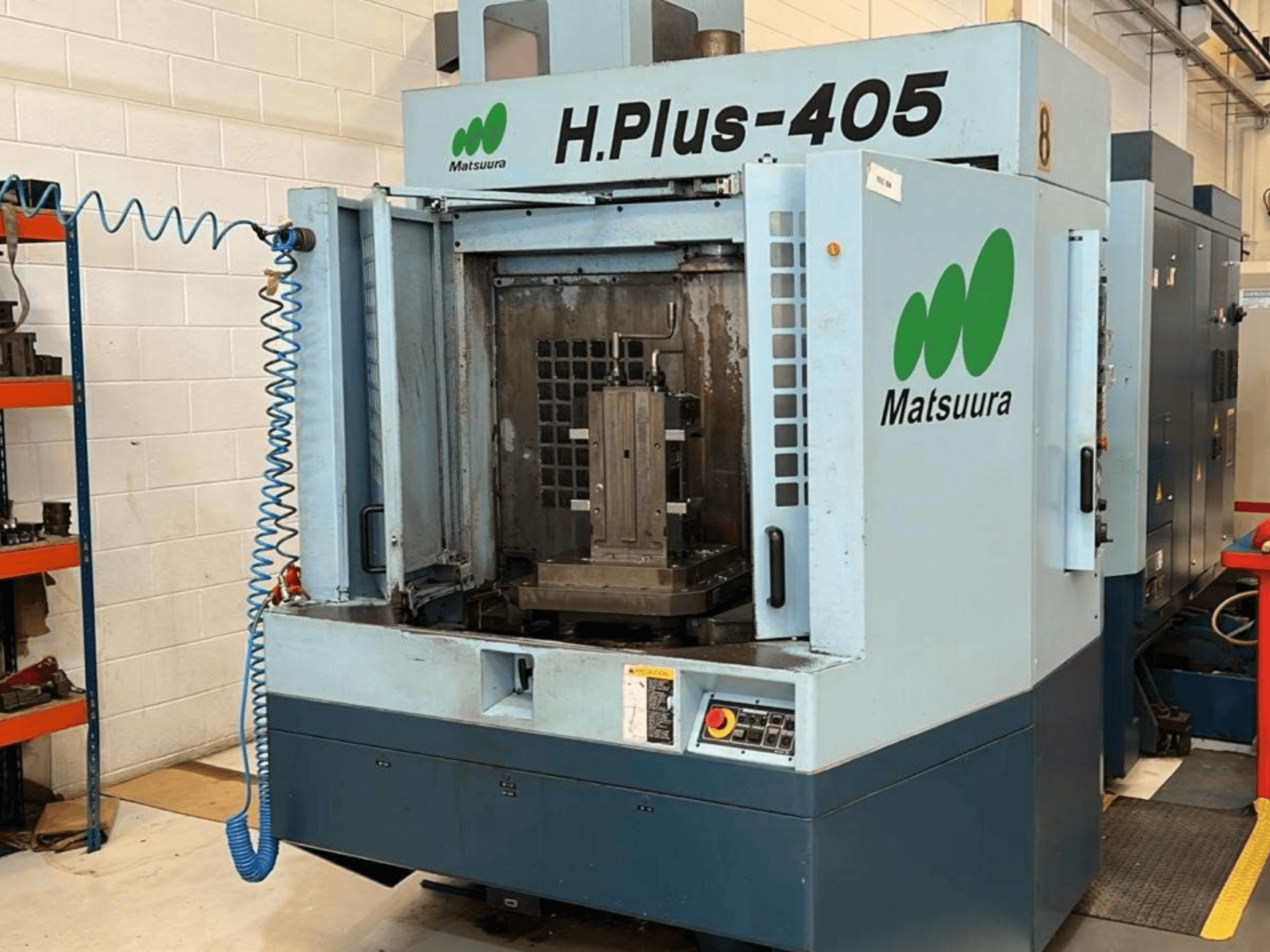 Vooraanzicht van een Matsuura H.Plus 405 horizontaal bewerkingscentrum met geopende deur, waarbij de werkruimte en het bedieningspaneel goed te zien zijn.