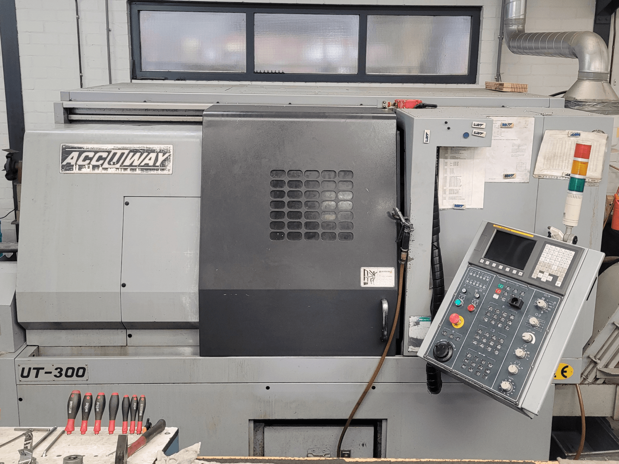 Accuway UT-300 CNC machine in vooraanzicht, met bedieningspaneel en diverse bedieningsknoppen, in een werkplaats.