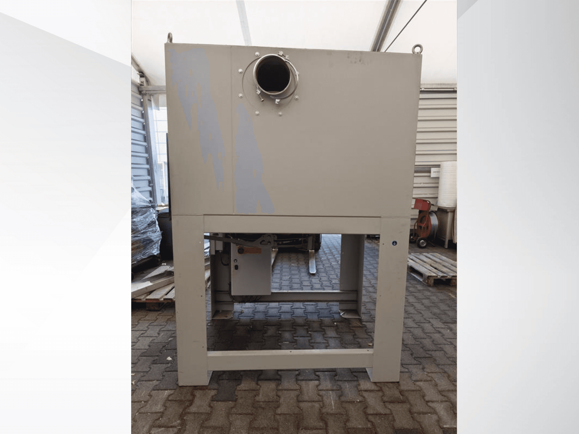 Grijze industriële stofafscheider gezien vanaf de voorkant, met een grote ronde opening en gemonteerd op een stevige basis.