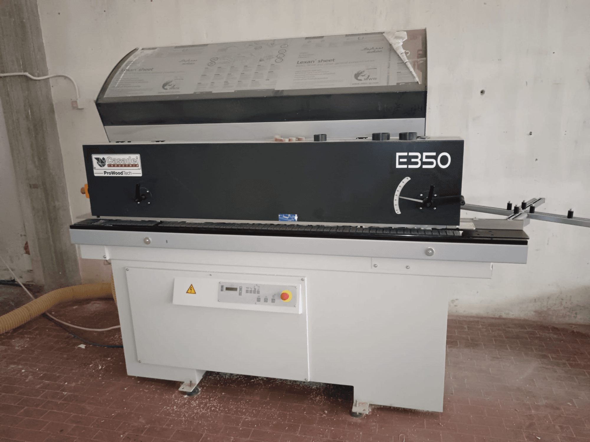 Cesaroli ProWoodtech E350, zijaanzicht van een houtbewerkingsmachine met bedieningspaneel en stofophoping, gemonteerd op een witte basis.