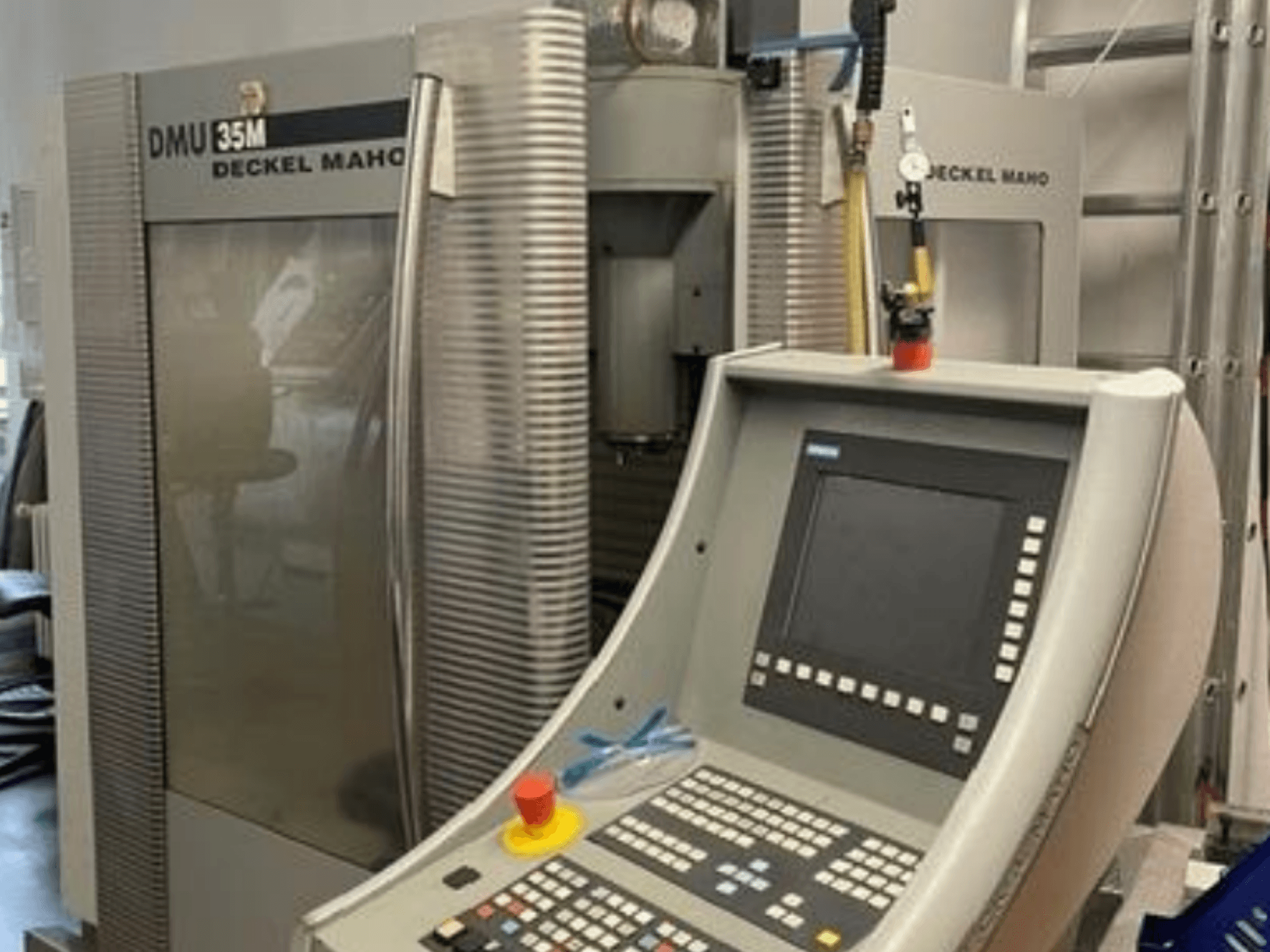 Vooraanzicht van het universele bewerkingscentrum DECKEL MAHO DMU 35M, met het bedieningspaneel en de machineonderdelen.
