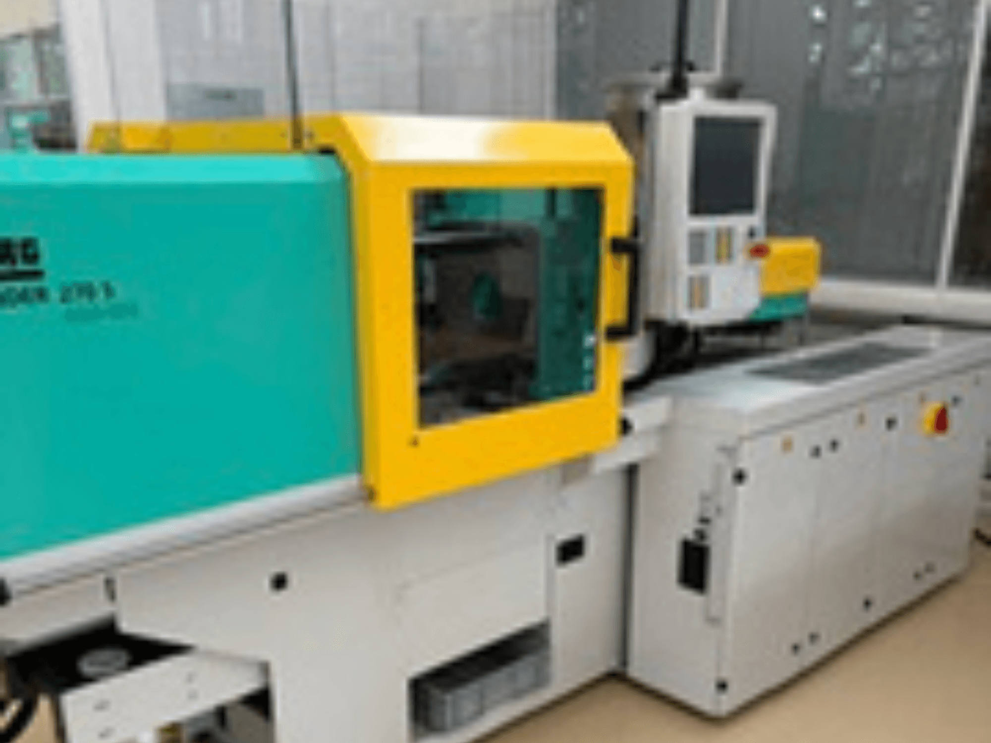 Vooraanzicht van de Arburg ALLROUNDER 270 S 400-100 hydraulische spuitgietmachine met bedieningspaneel en groengele behuizing.