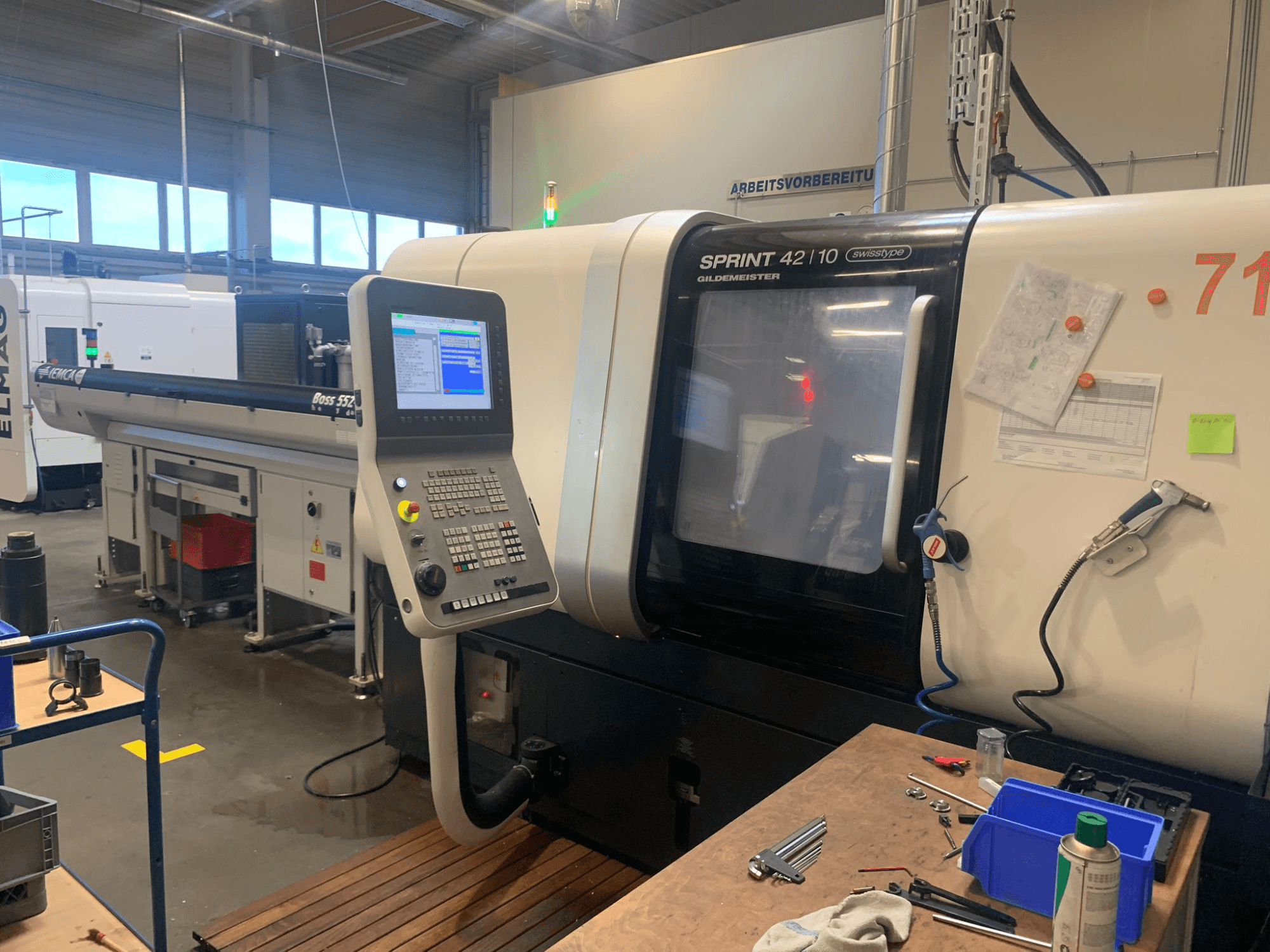 DMG MORI Sprint 42/10 lineaire Zwitserse draaimachine, vooraanzicht, met een bedieningspaneel en een rommelige werkruimte.