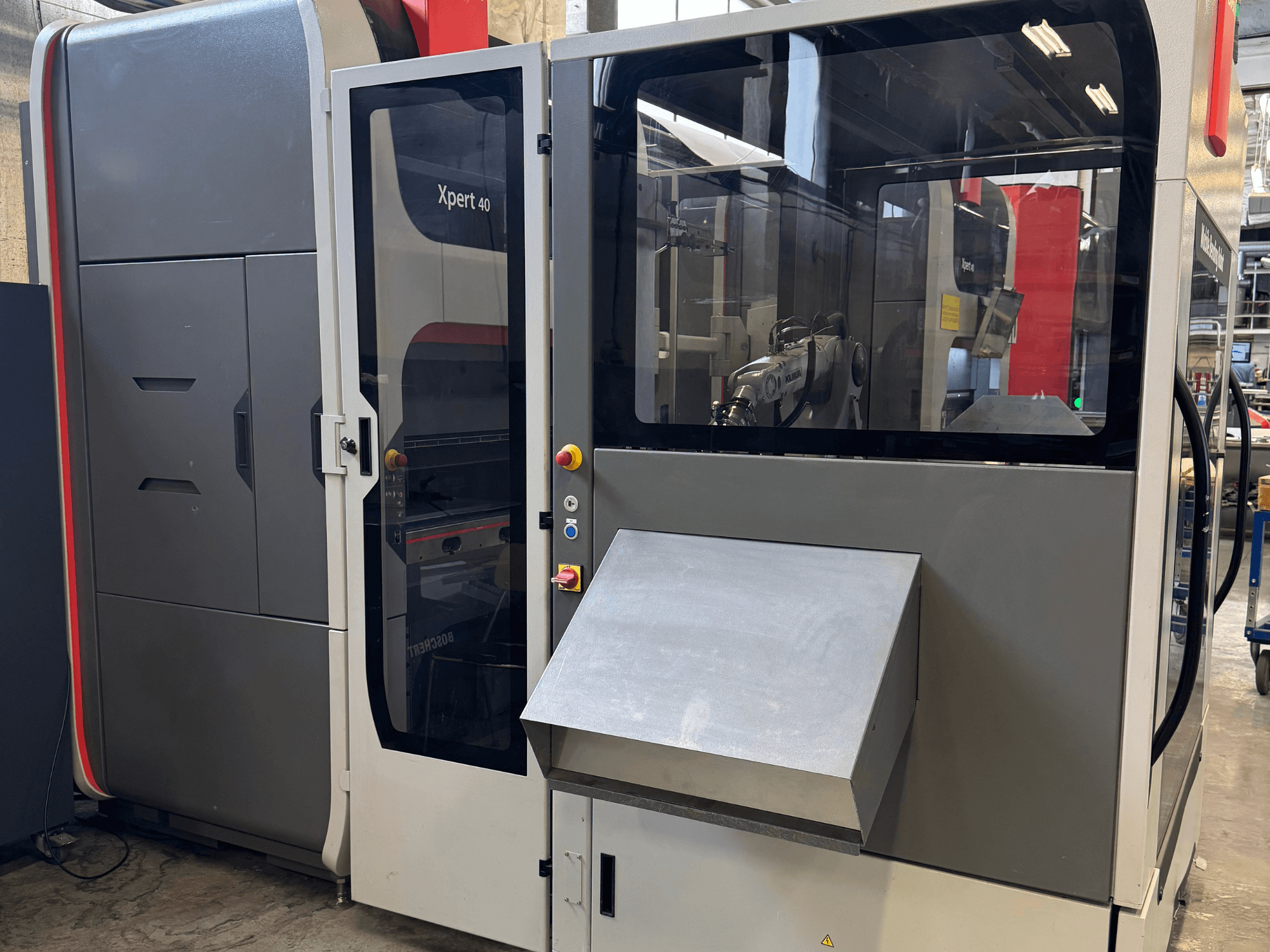De Bystronic Xpert 40/1030 afkantpers in vooraanzicht, met het bedieningspaneel, de glazen behuizing en de strakke designkenmerken.