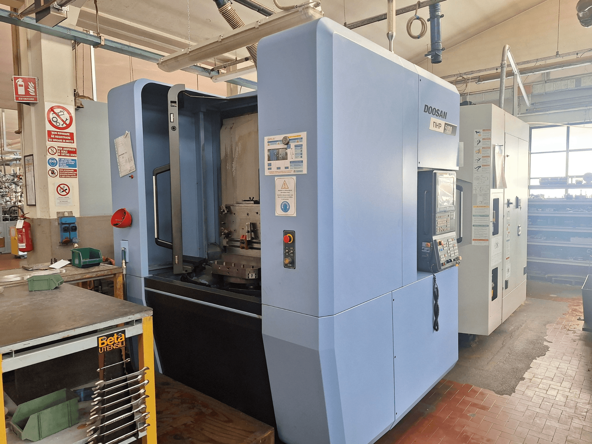 DOOSAN NHP 5000 horizontaal bewerkingscentrum in een werkplaats, zijaanzicht van het bedieningspaneel en het bewerkingsgebied.
