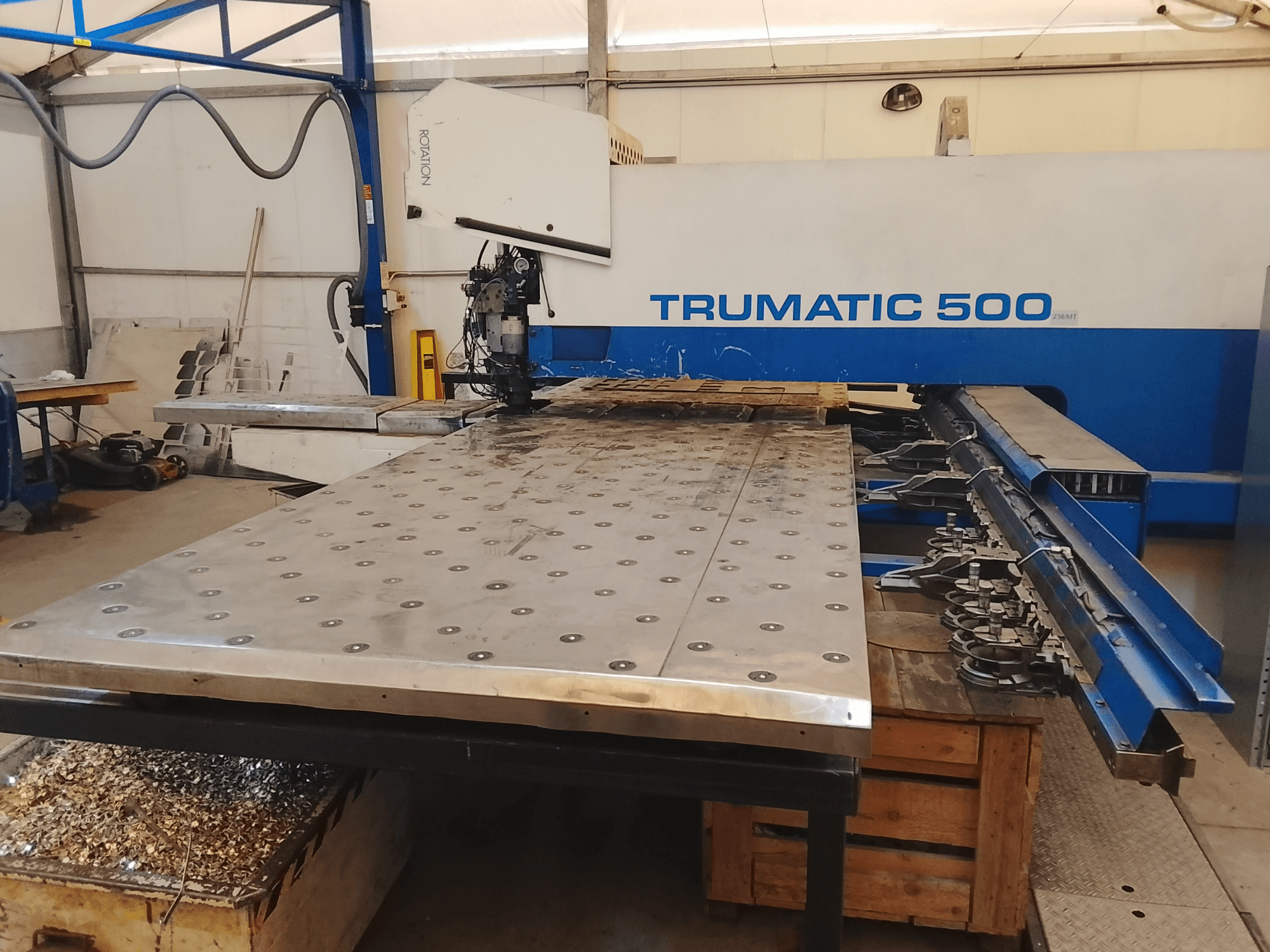 Trumatic 500 CNC machine, bovenaanzicht, met een grote metalen snijtafel met gemonteerde gereedschappen en spaanders eronder.