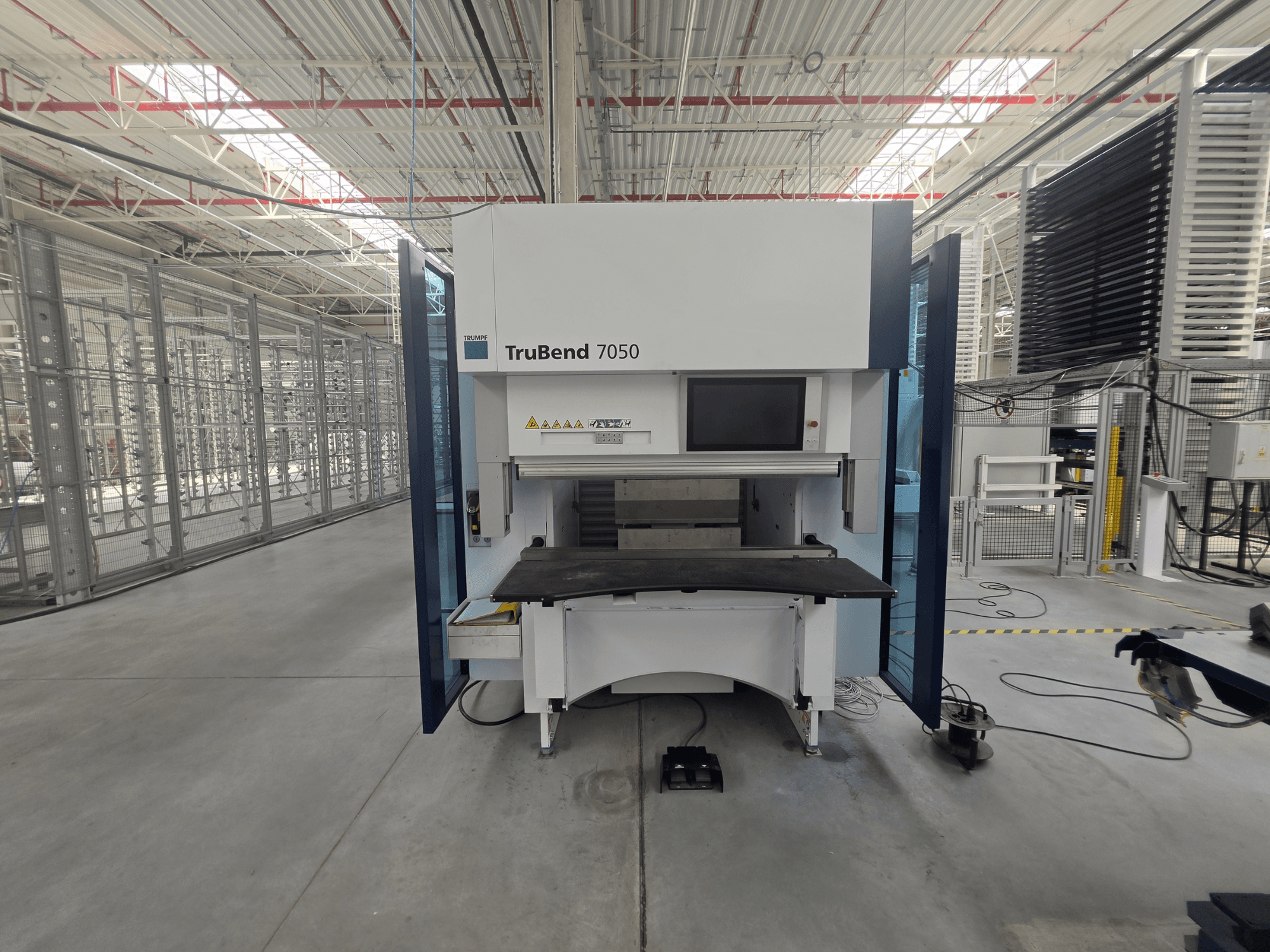 Vooraanzicht van de TRUMPF TruBend 7050 kantpers, met het bedieningspaneel en de werktafel in een goed verlichte industriële omgeving.