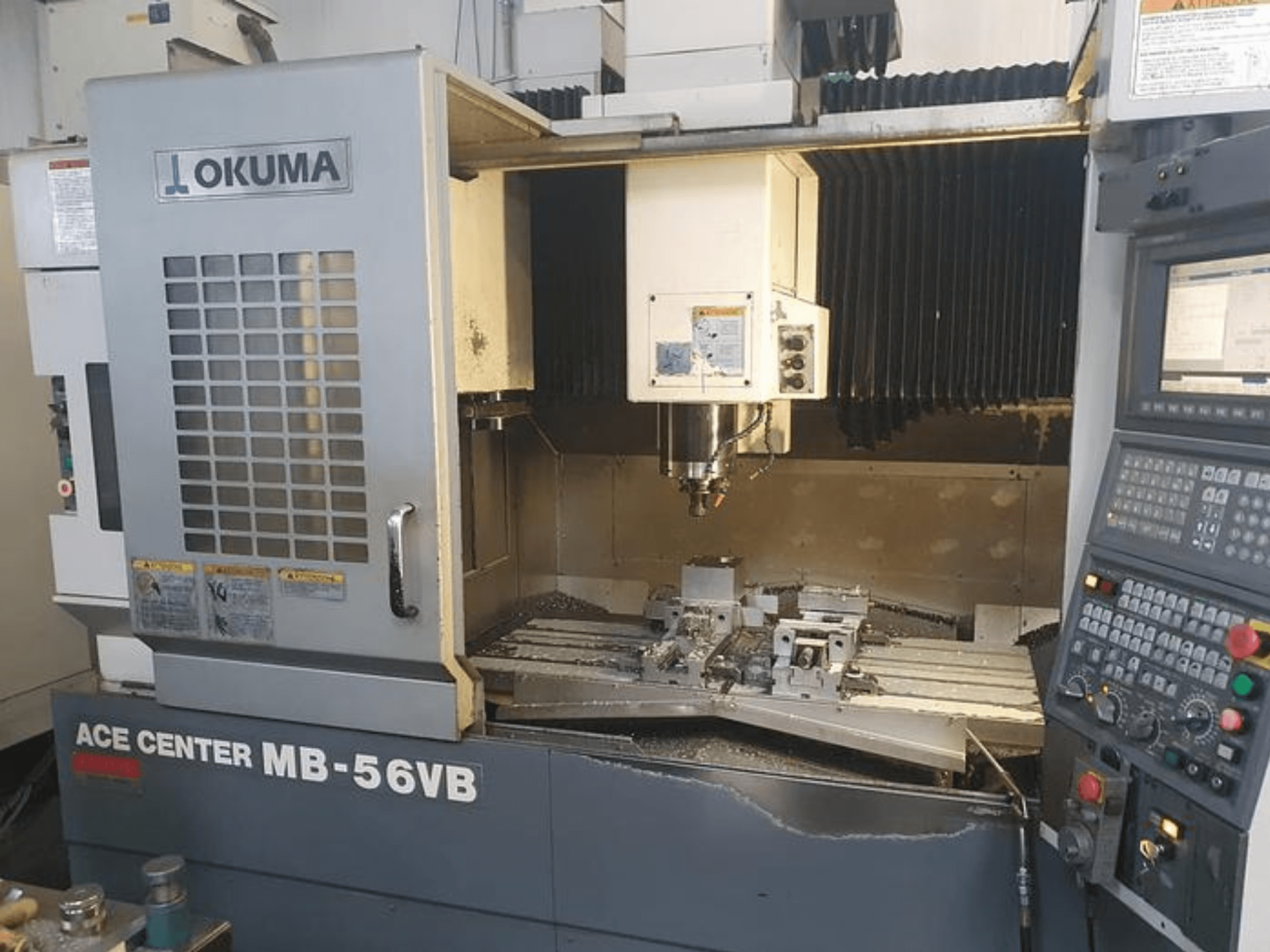 Okuma ACE CENTER MB-56VB CNC freesmachine in vooraanzicht, met het bedieningspaneel en het bewerkingsgebied.