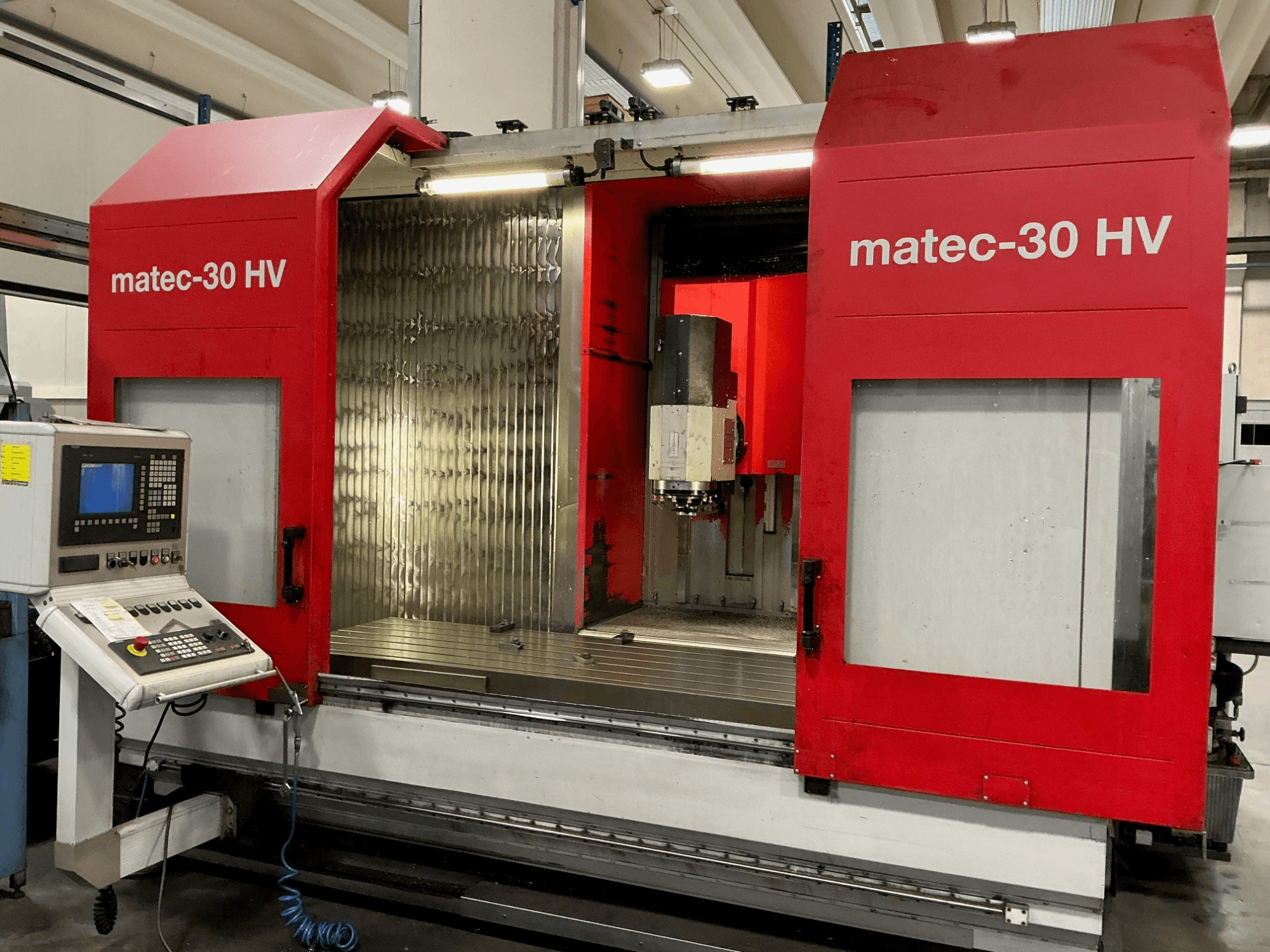 Rode Matec 30 HV verticaal bewerkingscentrum in vooraanzicht, met bedieningspaneel en open deuren die het snijgebied onthullen.