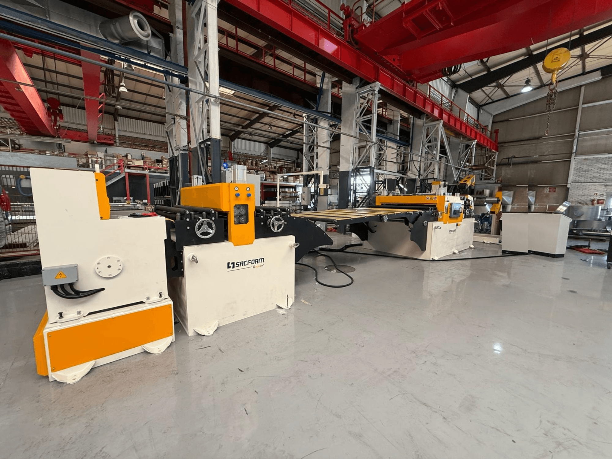 Vooraanzicht van de SACFORM CRL1503-6 plaatbewerkingsmachine, met een geel-wit ontwerp, wielen en bedieningselementen.