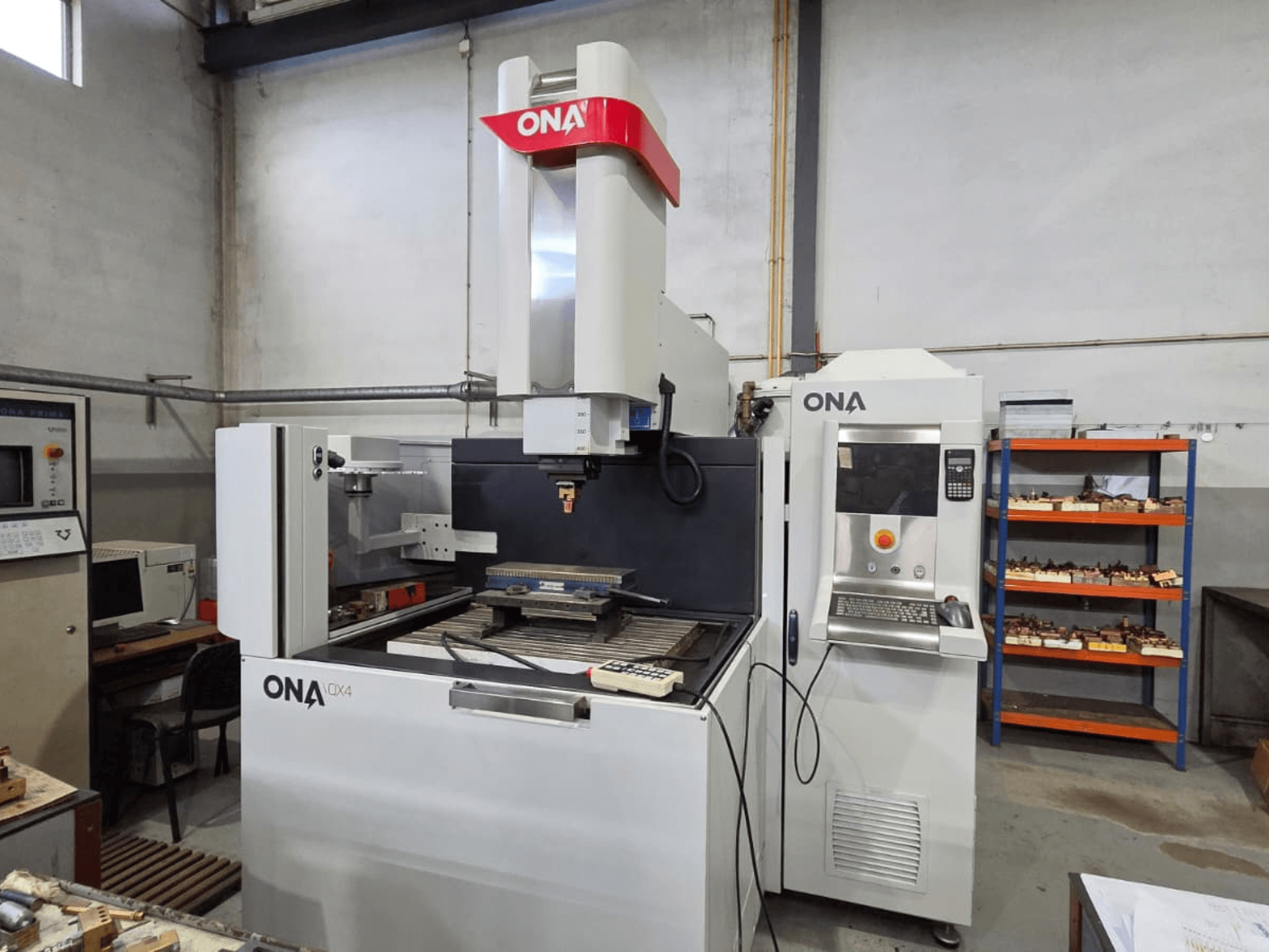ONA QX4 zinkvonkmachine in zijaanzicht, met bedieningspaneel en werktafel, in een werkplaats.