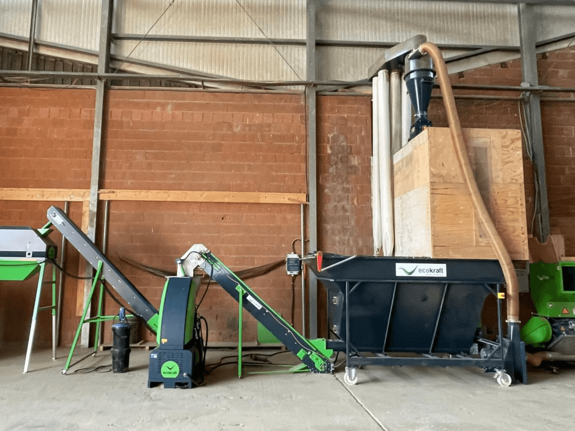 ECOKRAFT LP 22-bewerkingsmachine in een magazijn, voorzien van een transportband en een stofafzuigsysteem. Zijaanzicht, waarbij de functionele onderdelen duidelijk te zien zijn.