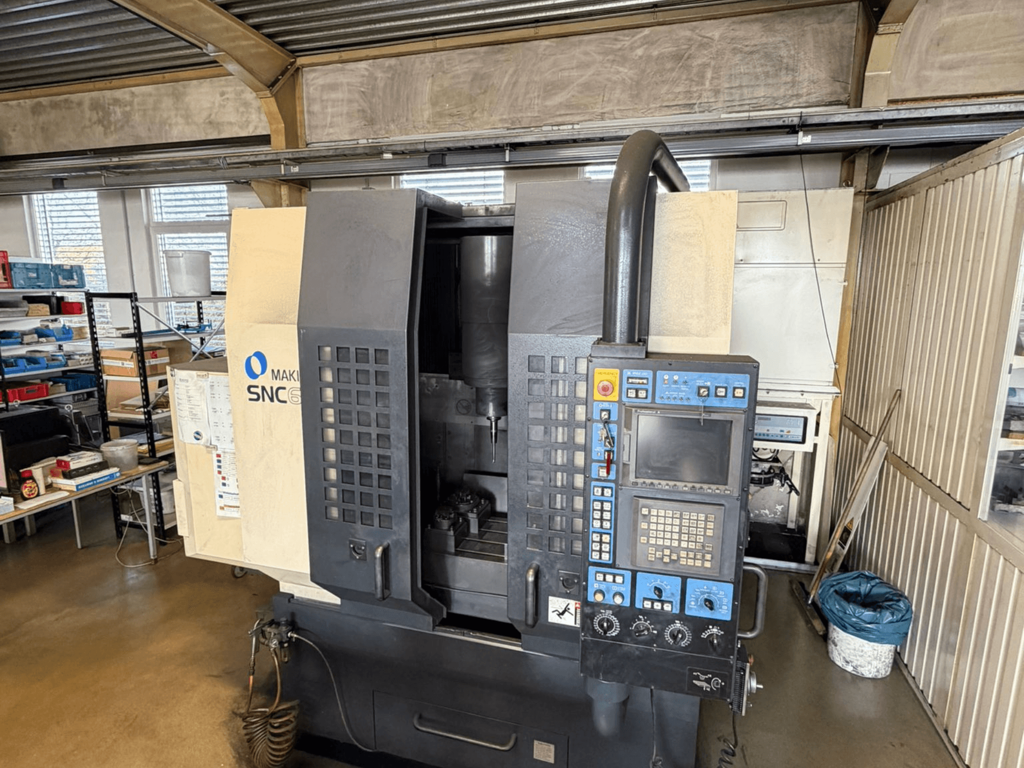 Makino SNC 64-A15 verticaal bewerkingscentrum in vooraanzicht, met het bedieningspaneel, het bewerkingsgebied en de industriële werkruimte.