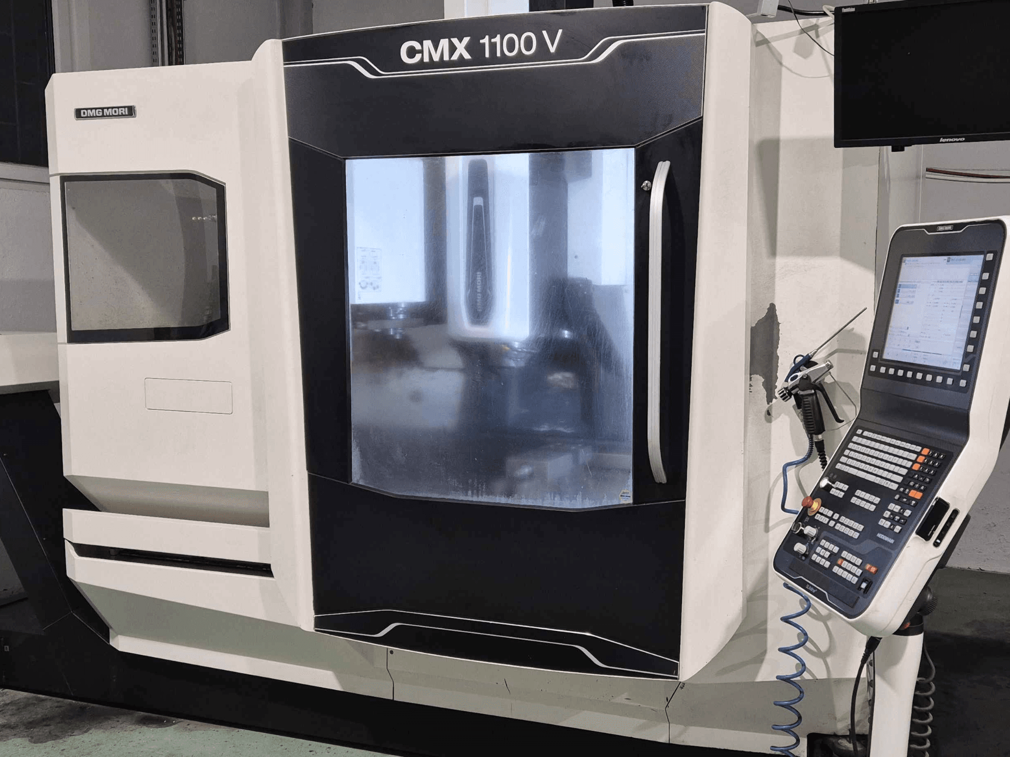 DMG Mori CMX 1100 V, vooraanzicht van CNC machine met bedieningspaneel, digitaal display en koelvloeistofinstelling zichtbaar.