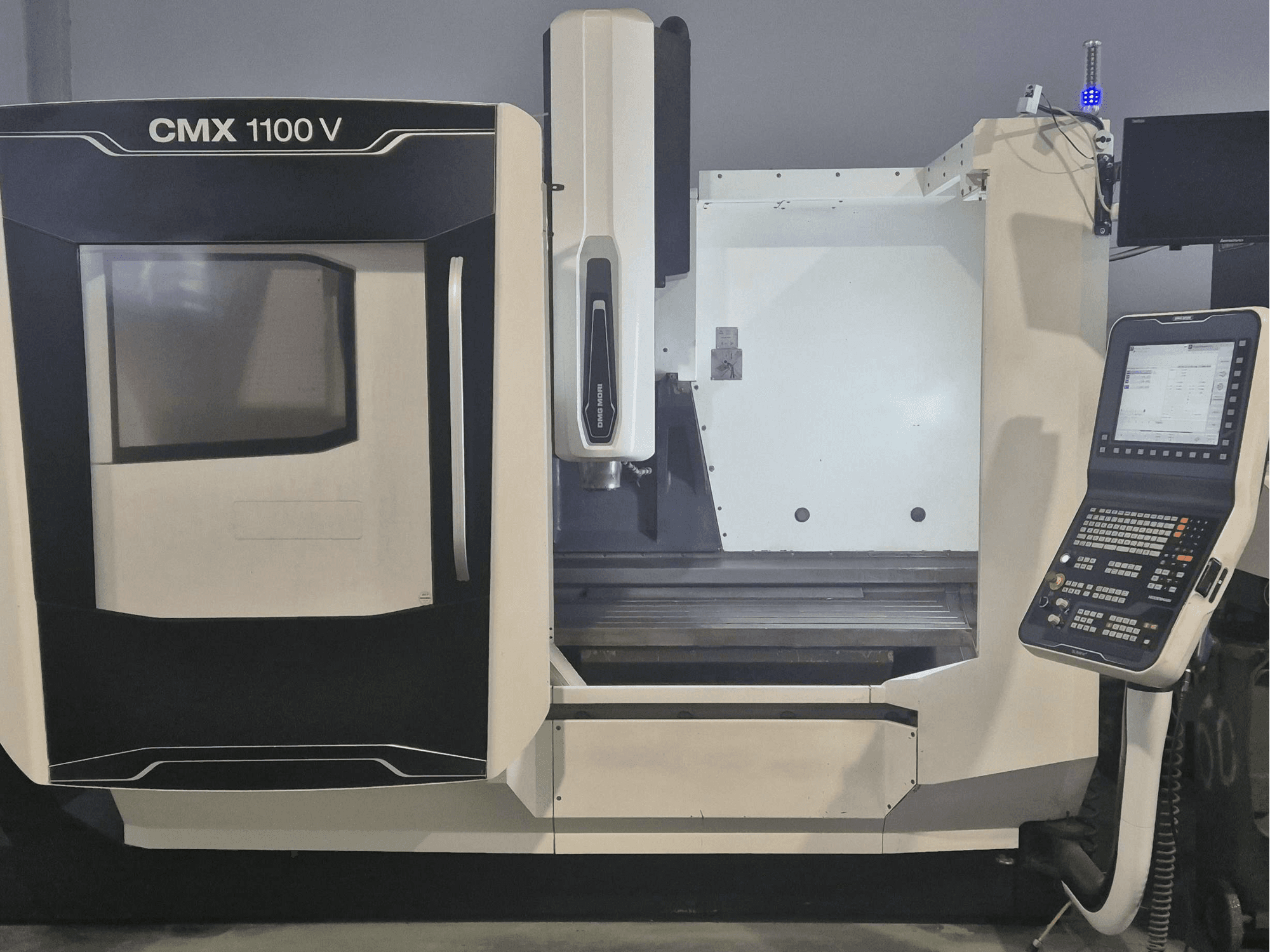 DMG MORI CMX 1100 V verticaal bewerkingscentrum, vooraanzicht met bedieningspaneel en machinebed.
