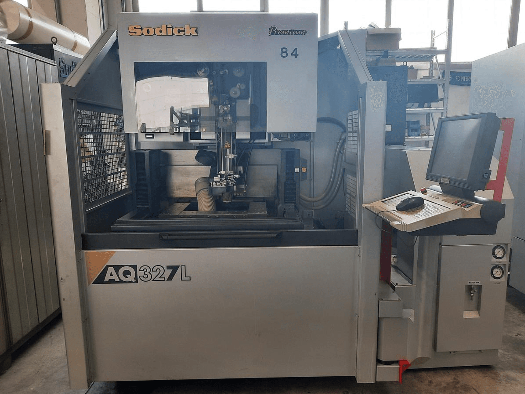 Sodick AQ327L machine in vooraanzicht, met bedieningspaneel, gebruikersinterface en zichtbare snijzone binnenin.