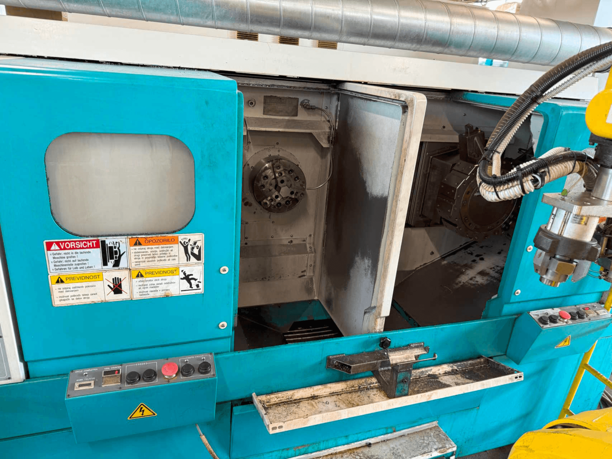 DOOSAN H310T horizontale draaimachine, vooraanzicht met bedieningspaneel en spindelgedeelte met veiligheidswaarschuwingen.